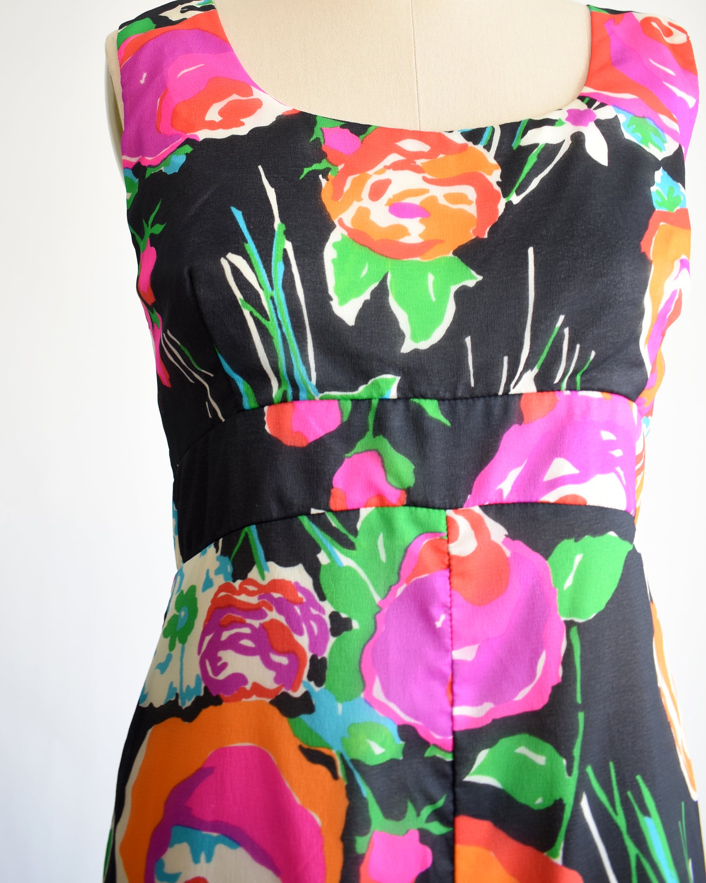 close up of the bodice of a vintage  1970s black floral print jumpsuit by Malia on a dress form