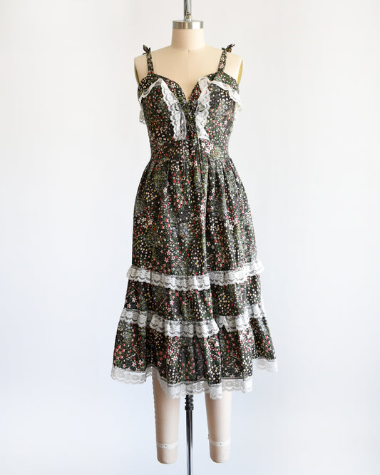 a vintage 1970s dark floral and lace trim dress on a cream dress form against a white background
