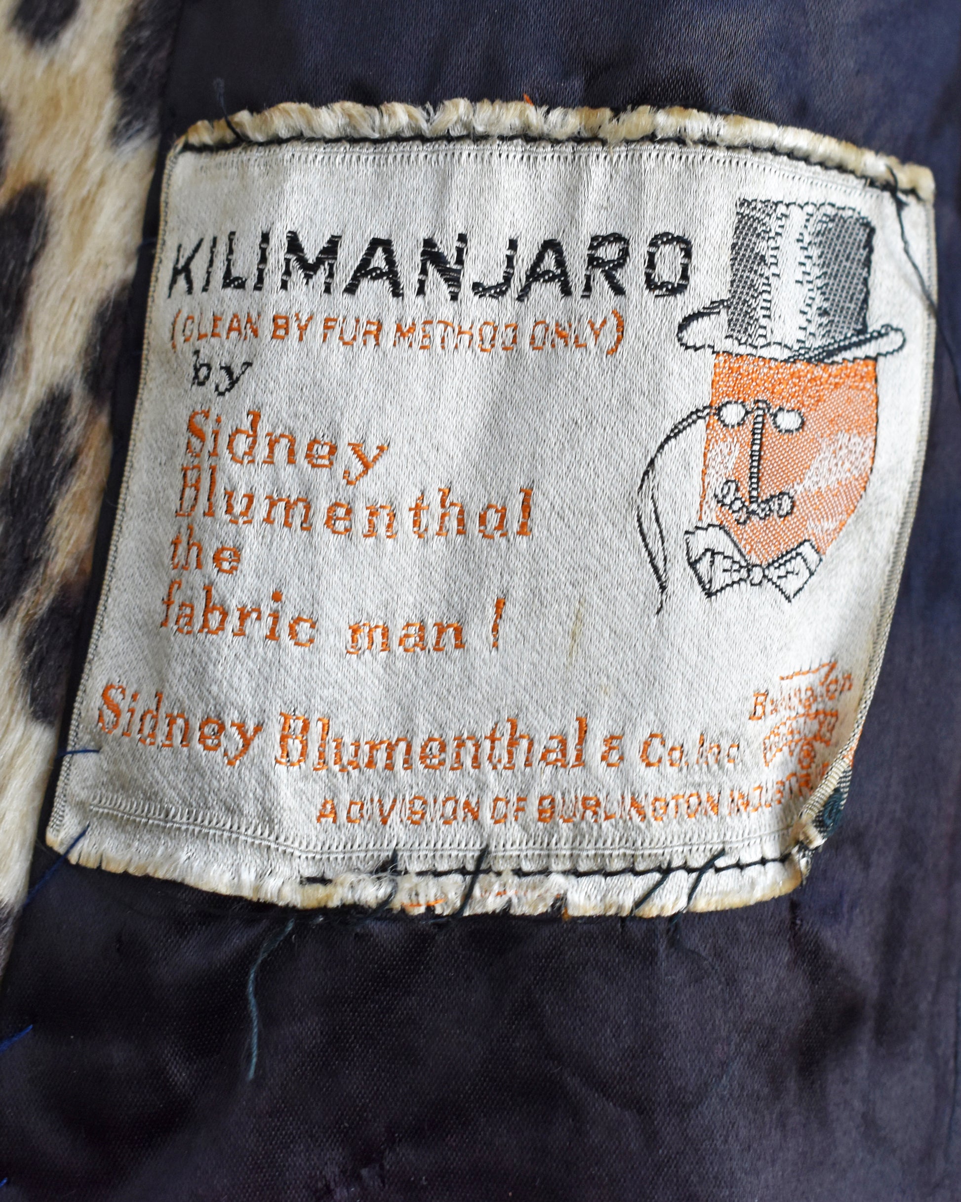 close up of the coat's label that says Kilimanjaro, Sidney Blumenthal & Co., a division of Burlington Industries Care 