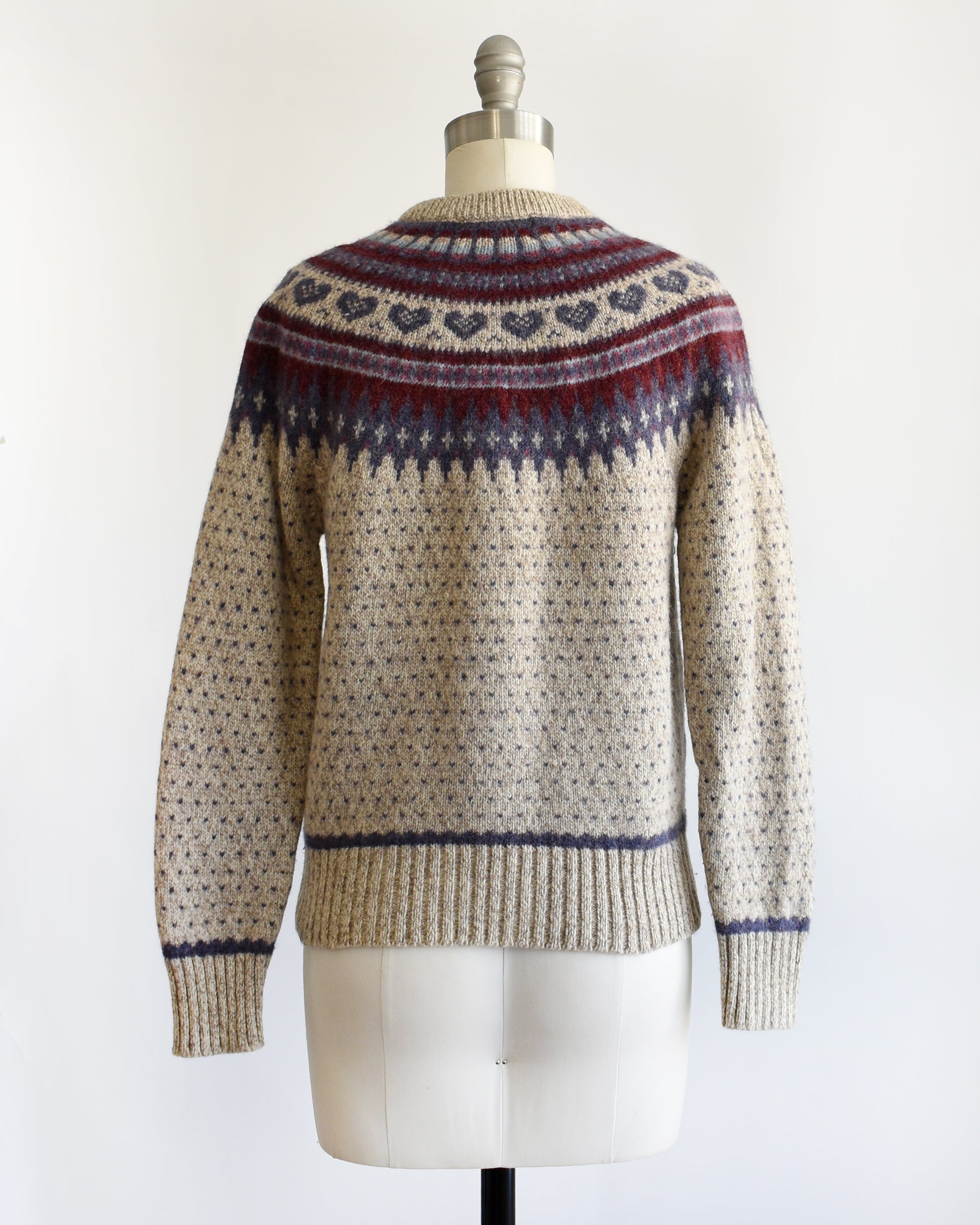 back view of a vintage 1990s knitted fair isle hearts sweater by Eddie Bauer on a mannequin against a white background