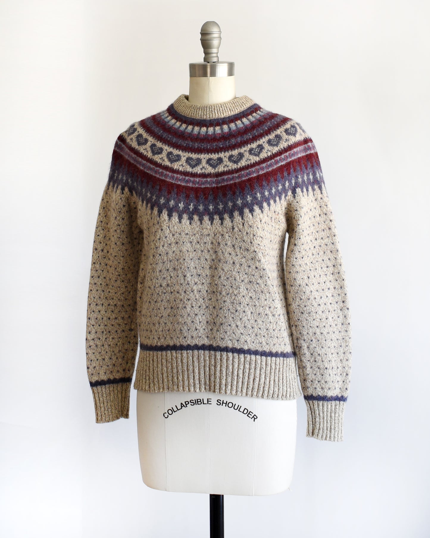 side front view of a vintage 1990s knitted fair isle hearts sweater by Eddie Bauer on a mannequin against a white background