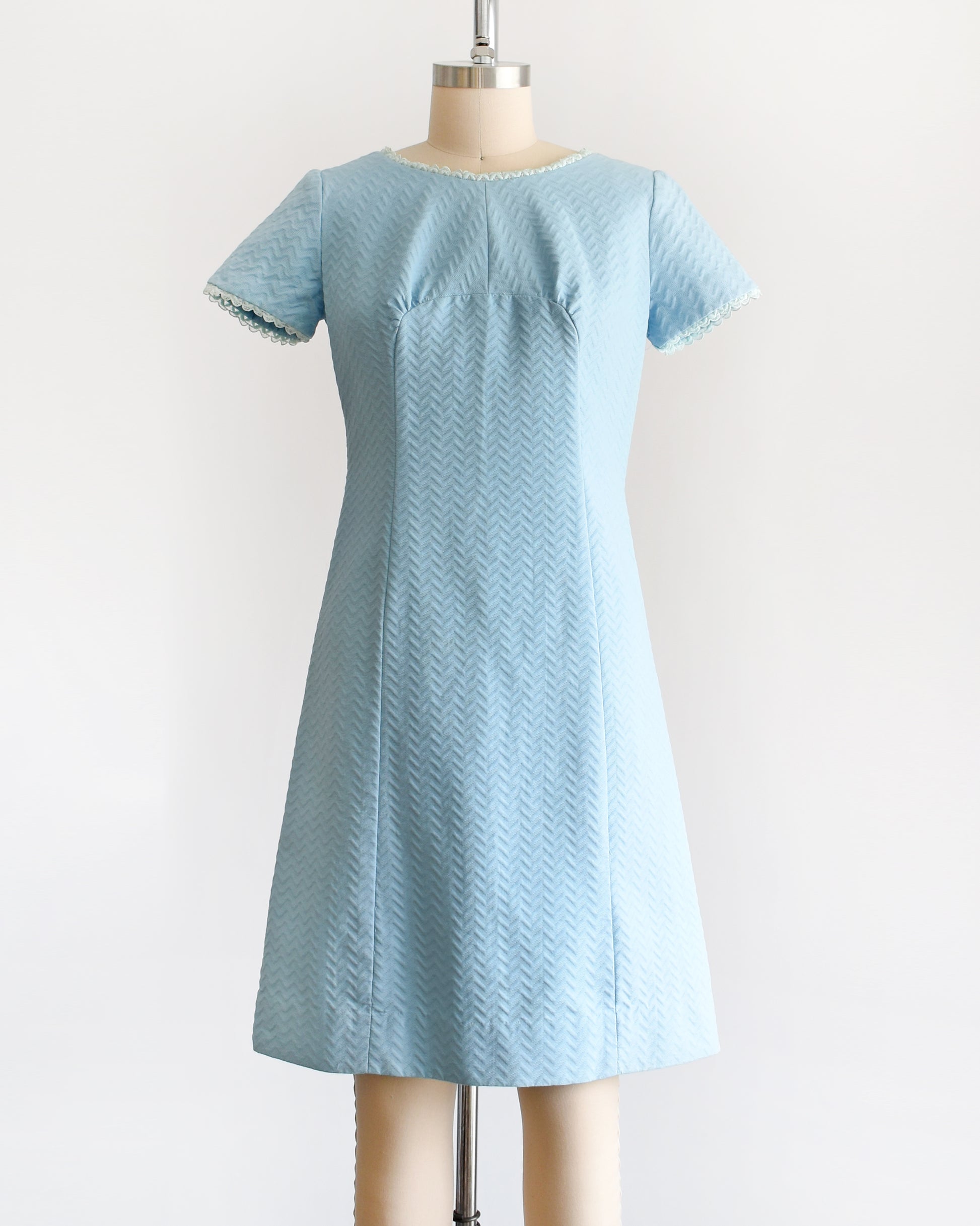 A vintage 1960s mod dress that has textured light blue chevron striped knit with alternating ribbing. 