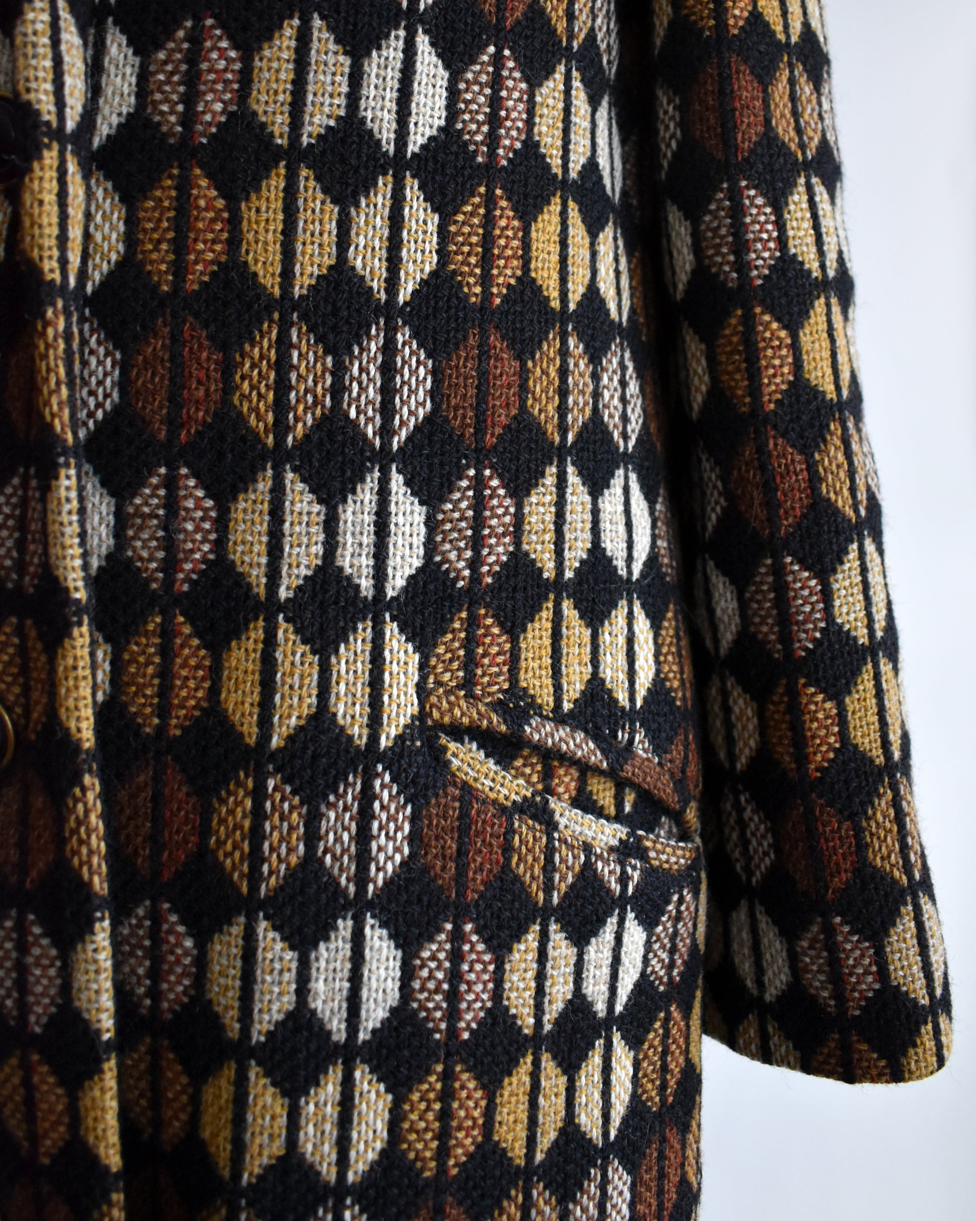 Close-up of a patterned coat with geometric design on a white background