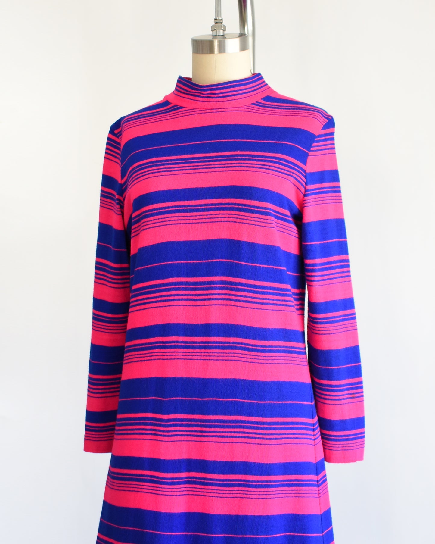 side front view of a vintage 1960s pink and blue horizontal mod dress on a dress form