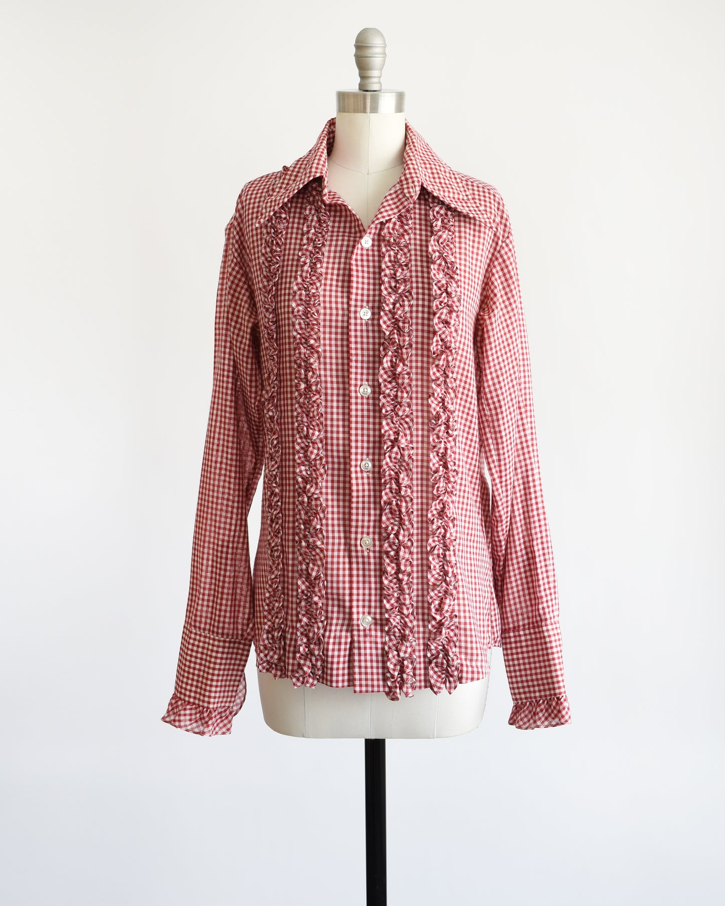 A vintage 1970s red and white gingham check with plastic buttons down the front and two on the ruffled cuffs