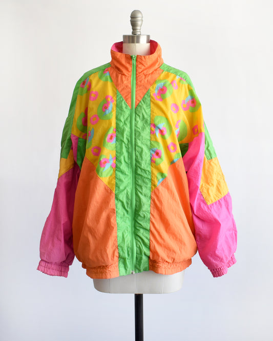 a vintage 1990s color block neon windbreaker on a dress form against a white background