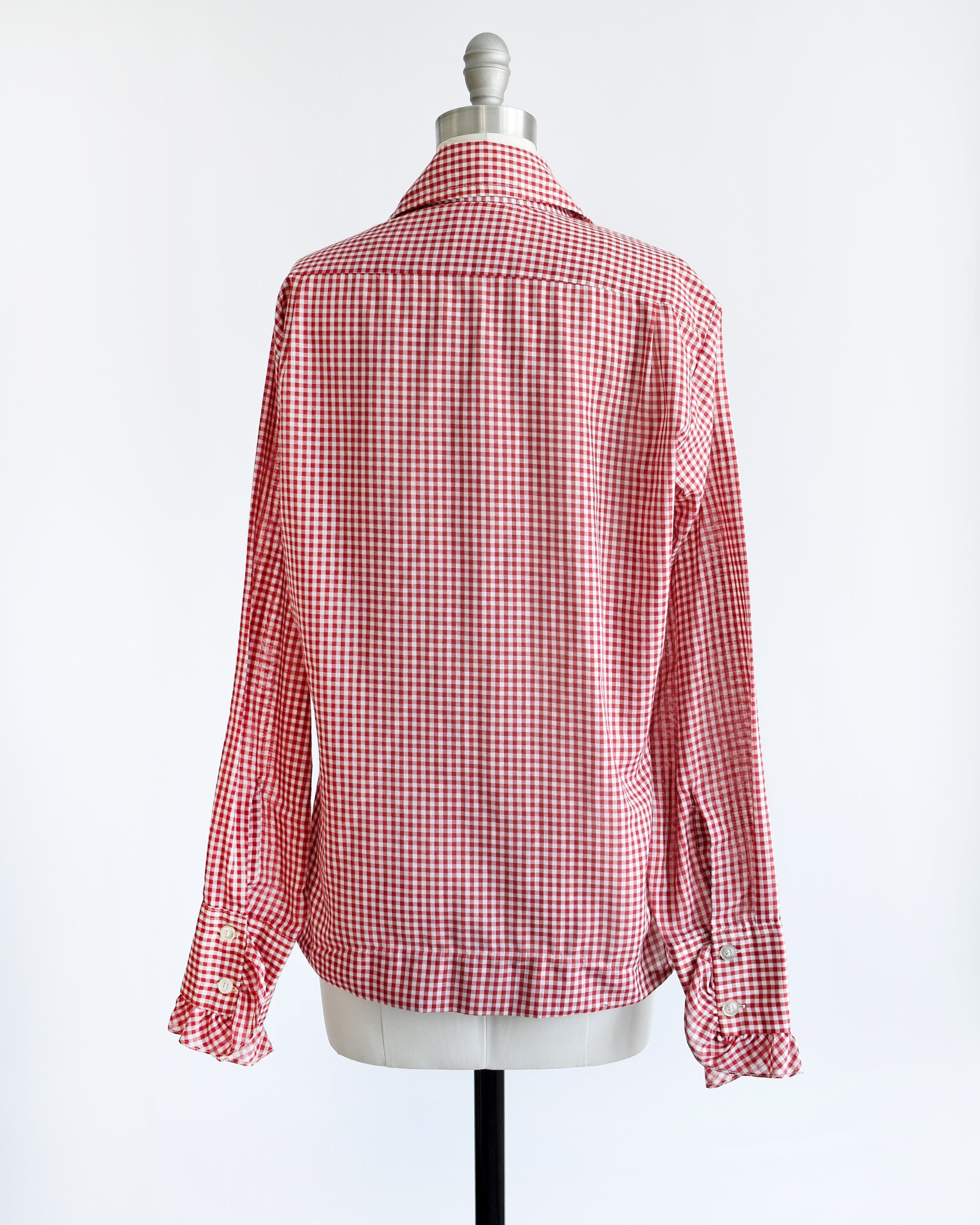 Back view of a vintage 1970s red and white gingham check with tow plastic buttons  on the ruffled cuffs