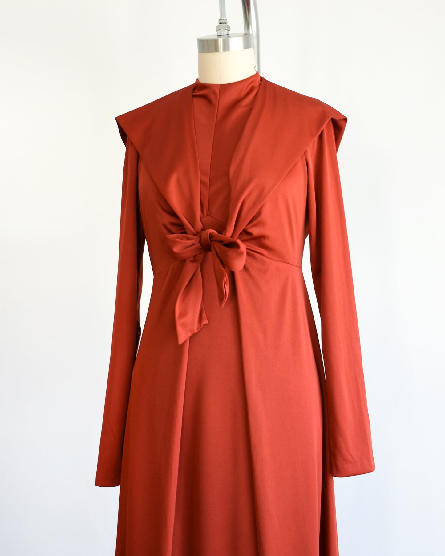 side front view of side by side of a a vintage 1970s rust red hooded maxi dress set.