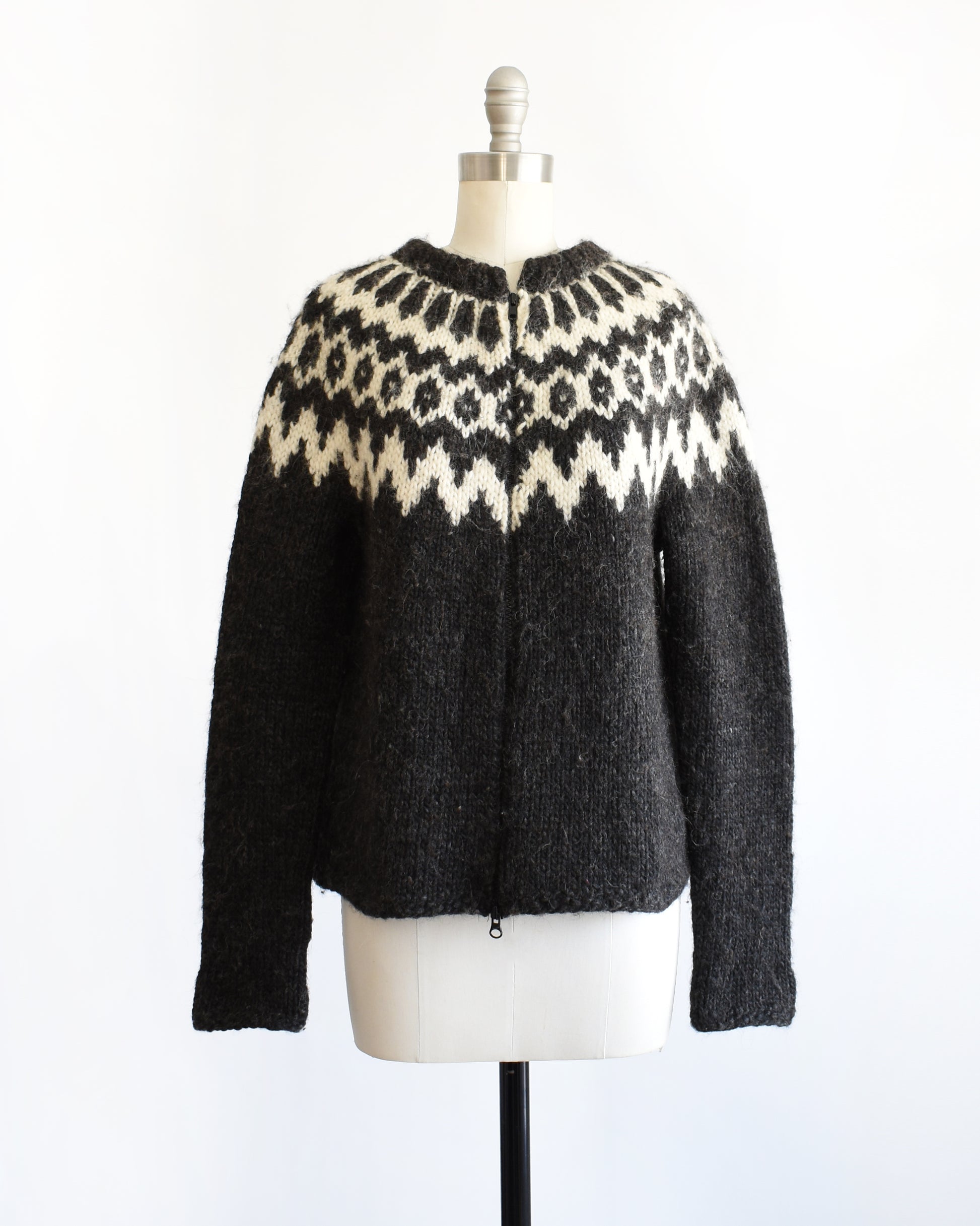 a vintage black and white Fair Isle patterned sweater on a mannequin against a white background