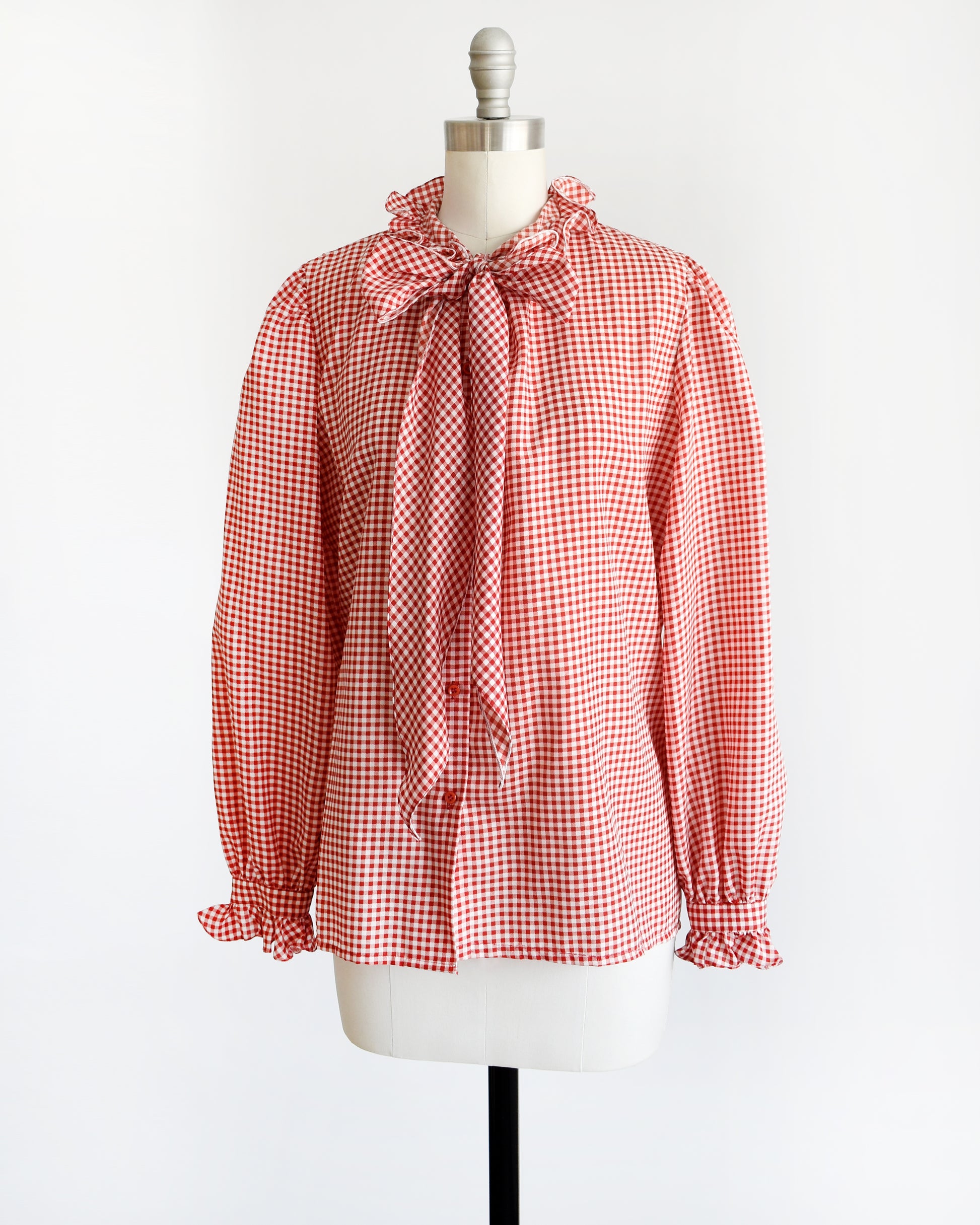 Side front view of a vintage 1980s red and white gingham blouse with ruffled collar and ascot bow