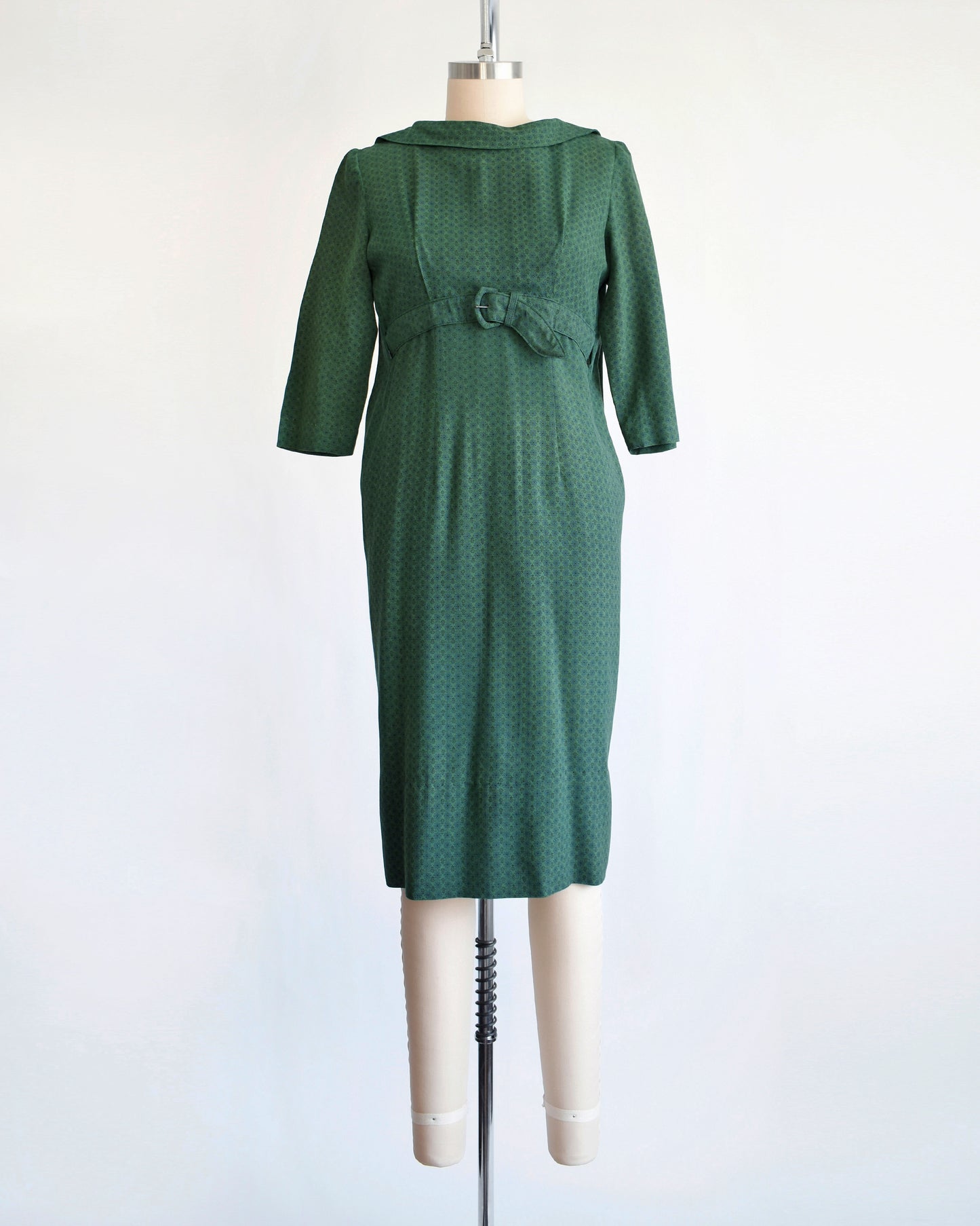 a vintage late 1950s early 1960s green floral wiggle dress with empire waist belt