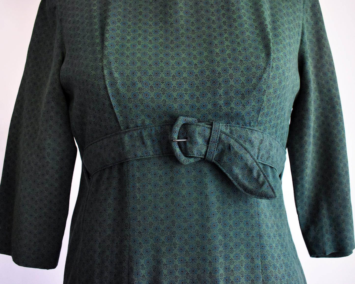 close up of the empire waist belt on a a vintage late 1950s early 1960s green floral wiggle dress