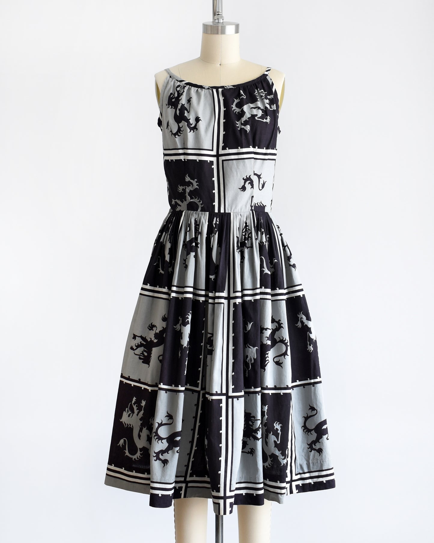 A vintage 1950s  that has a black and light gray checkered pattern with a Scottish lion in each center, framed by black and white stripes. The dress is shown without a crinoline slip underneath.