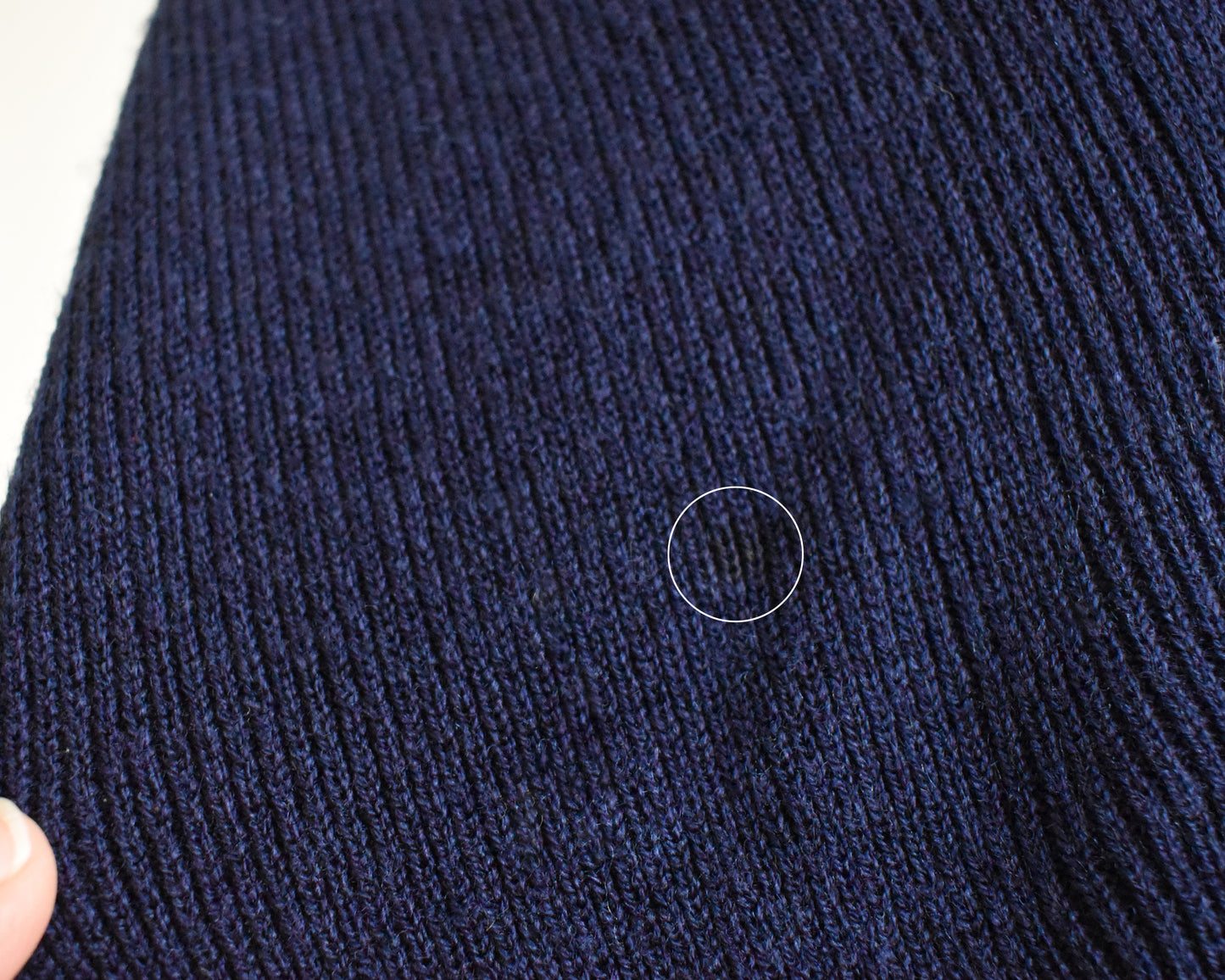 close up of a small dark spot on the front of the sweater