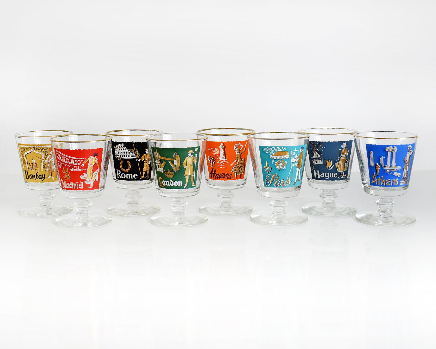 This Libbey International Set features 8 mid century city colorful glasses with distinct scenes, metallic gold/white accents. The glasses are Rome, Madrid, Bombay, Paris, Havana, Athens, London, The Hague