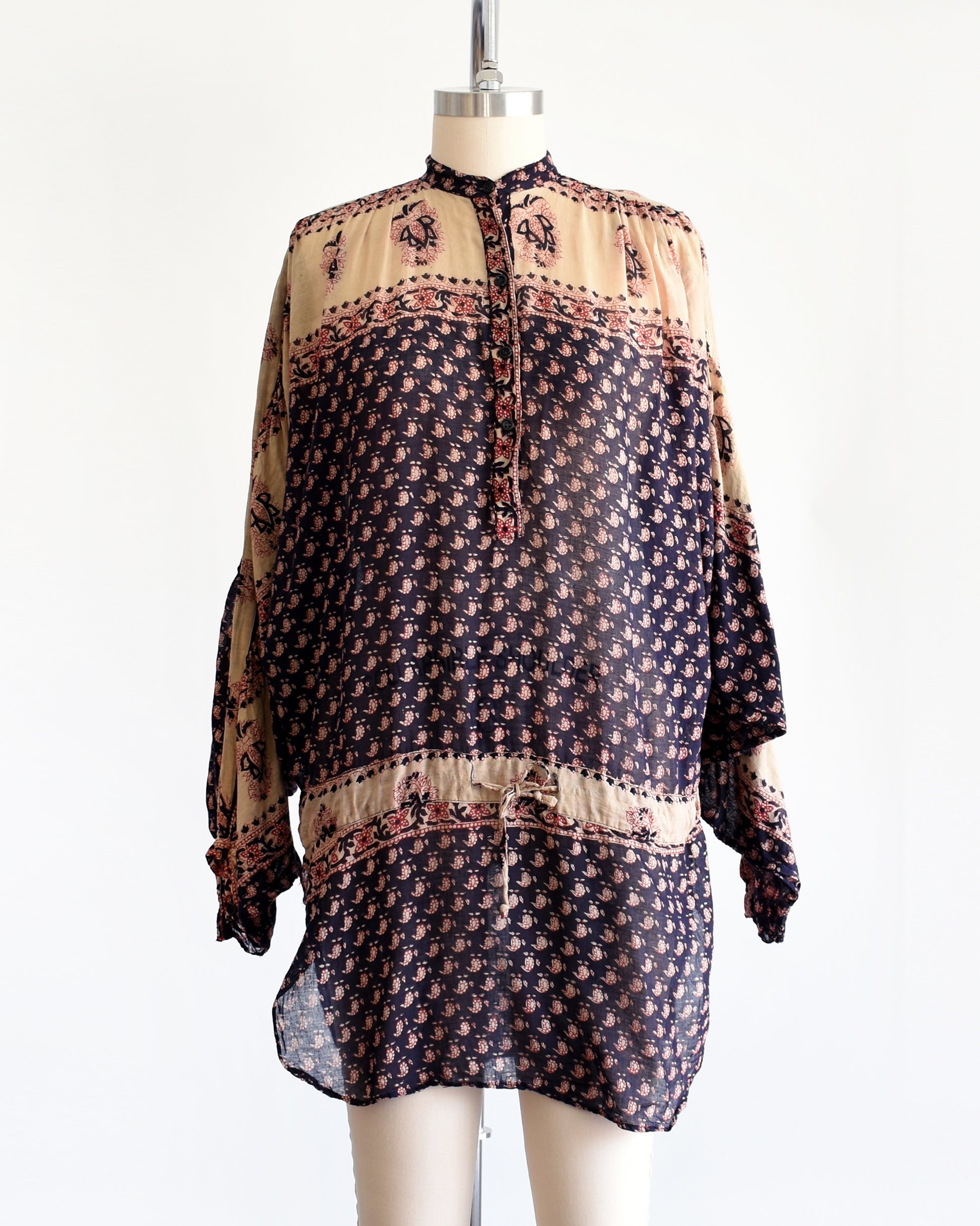 A vintage 1970s Indian cotton tunic made from thin, gauzy navy blue and light tan cotton with a red and navy floral block print