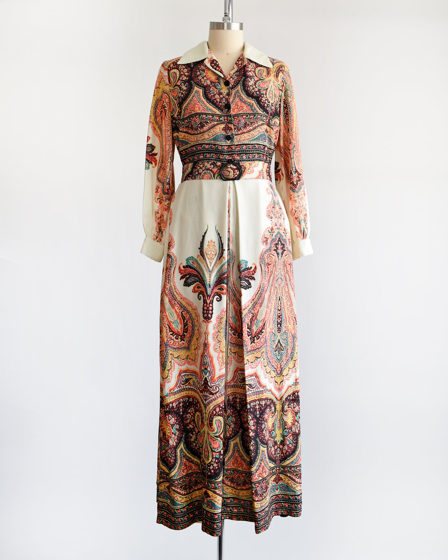 A vintage 1970s psychedelic paisley maxi dress with button front and matching belt that has a black buckle.