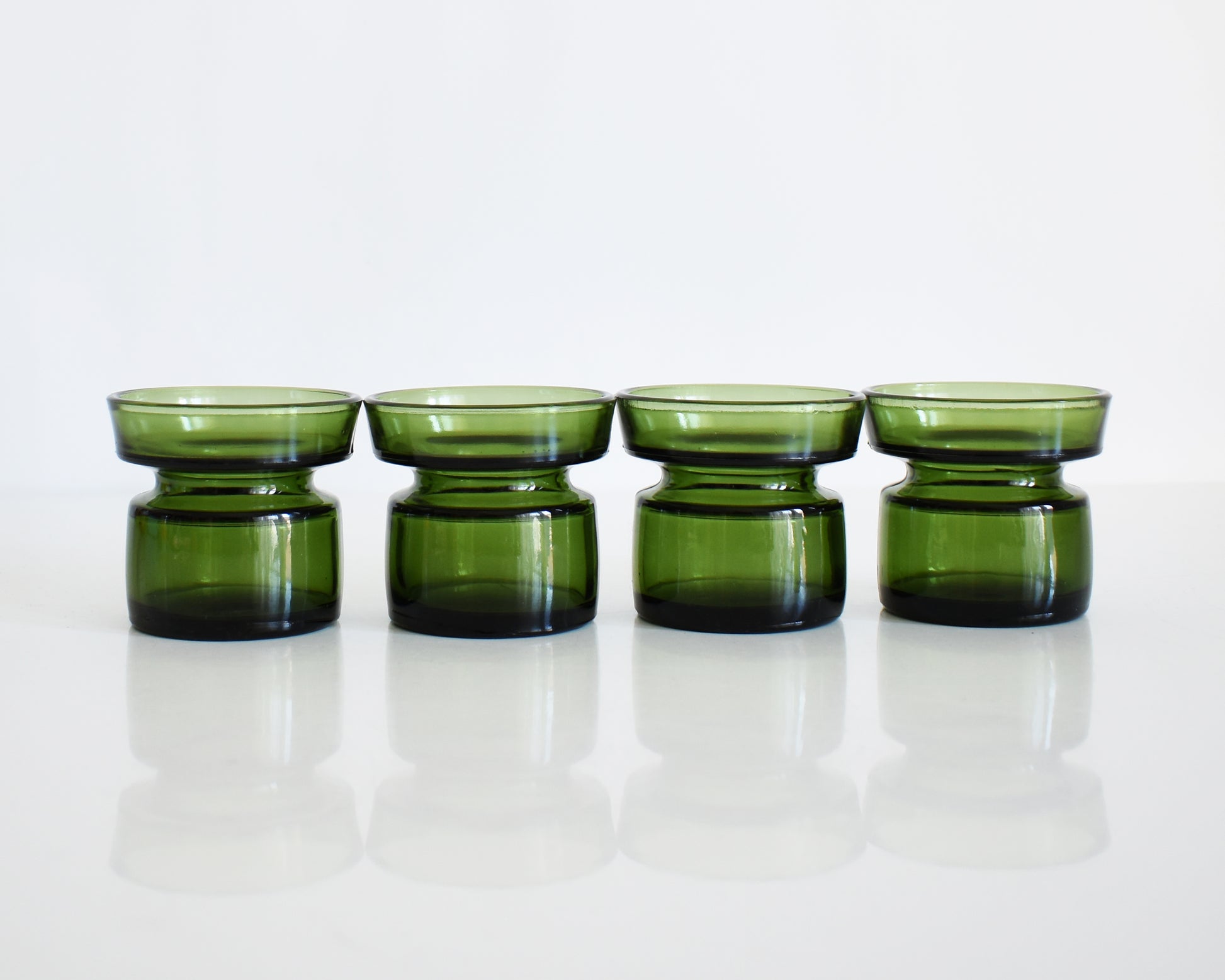 Set of four vintage 1960s green glass Dansk candle holders in a row