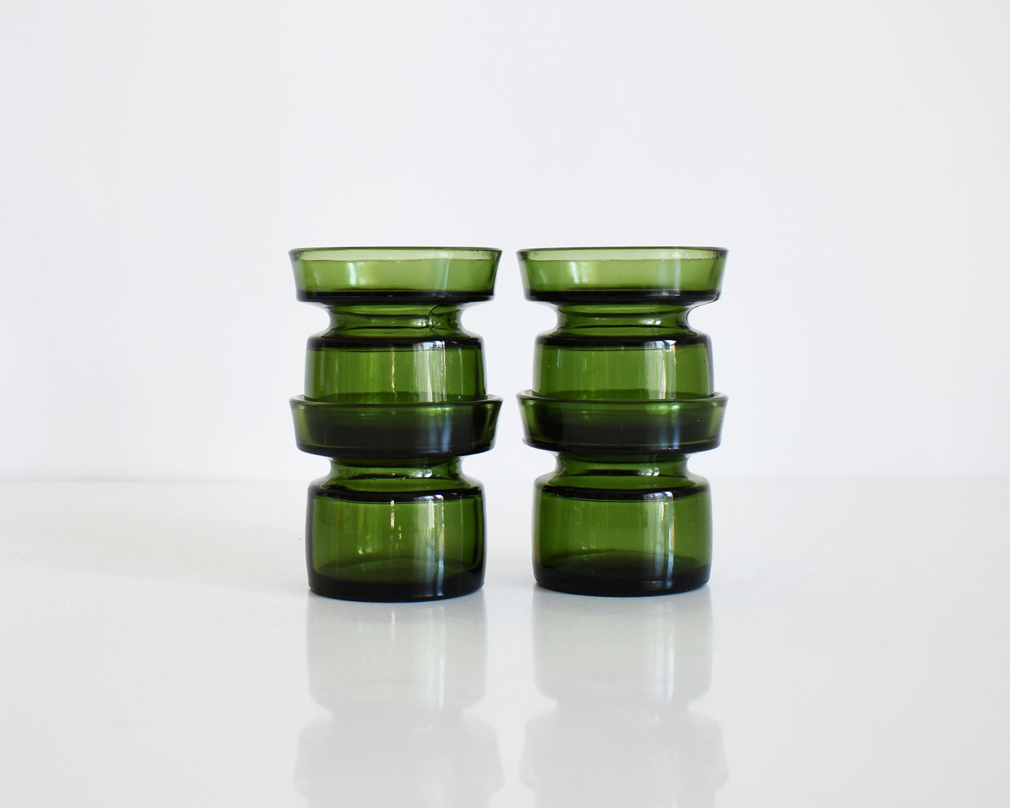 Set of four vintage 1960s green glass  Dansk candle holders. The candle holders are stacked into twos in this photo