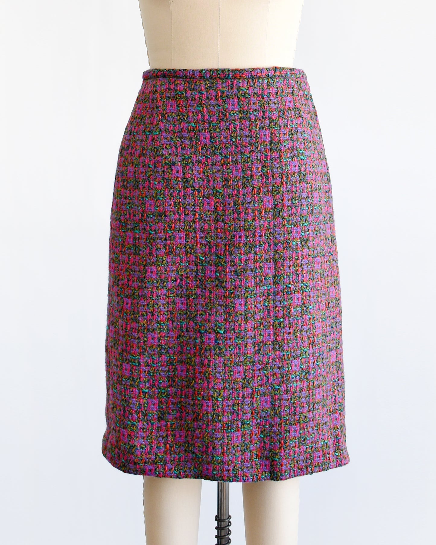 This 1960s vintage tweed skirt showcases multi-colored woven wool, displaying a palette of bright pink, purple, teal, brown, green and red hues