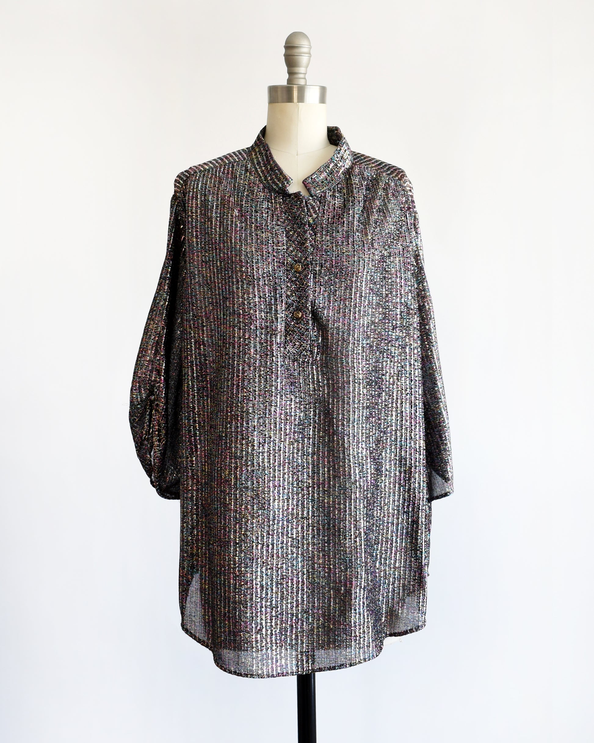 a vintage 1970s black rainbow metallic blouse on a dress form against a white background. The top isn't belted in this photo