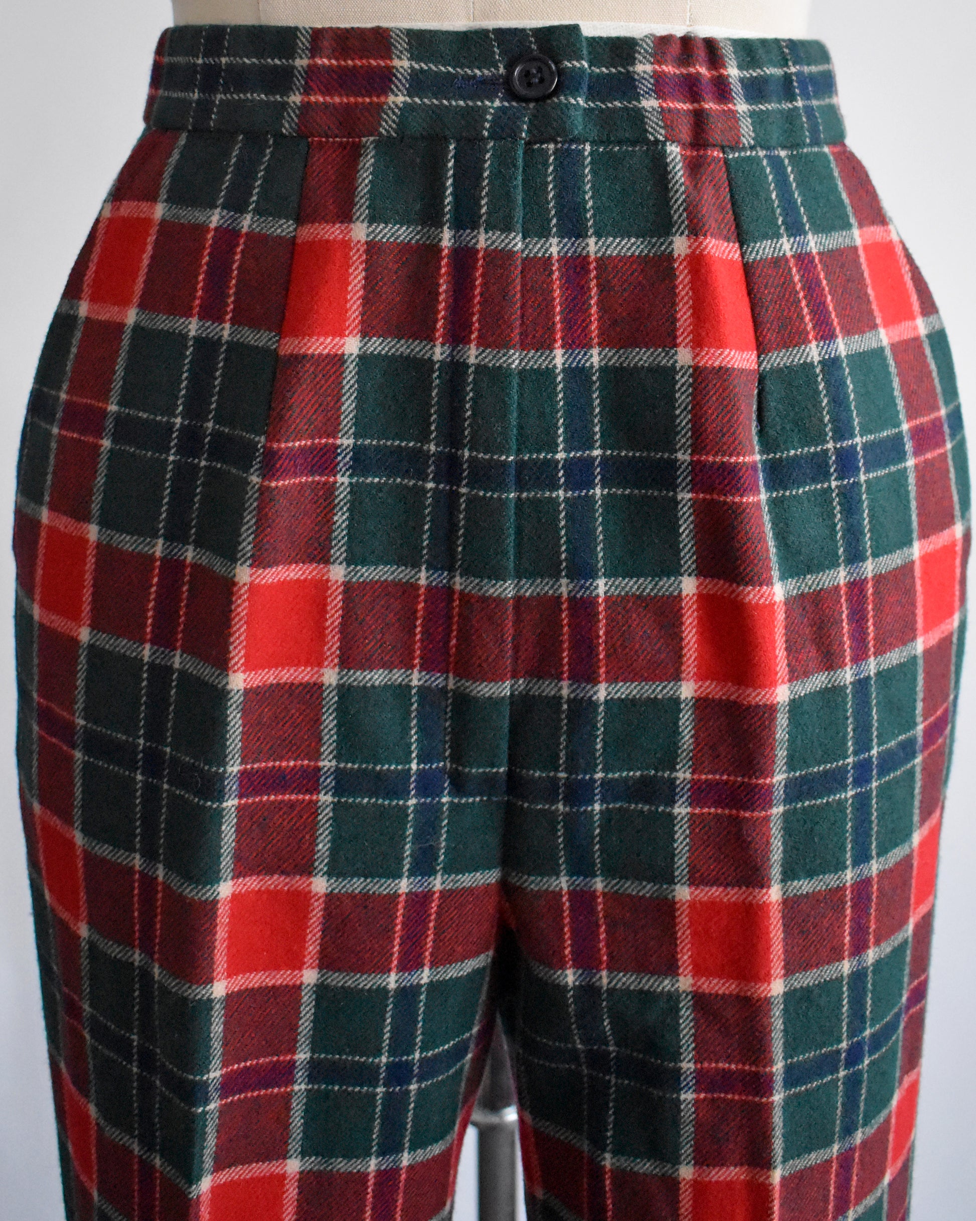 close up of the waist and hip area of a pair of vintage 1970s red, navy blue, green, and white plaid wool pants by Pendleton.