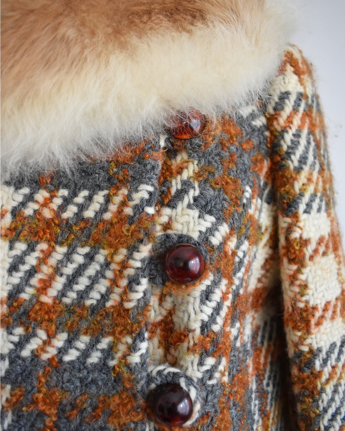 close up of the buttons on a vintage 1960s plaid wool coat with guanaco fur trim