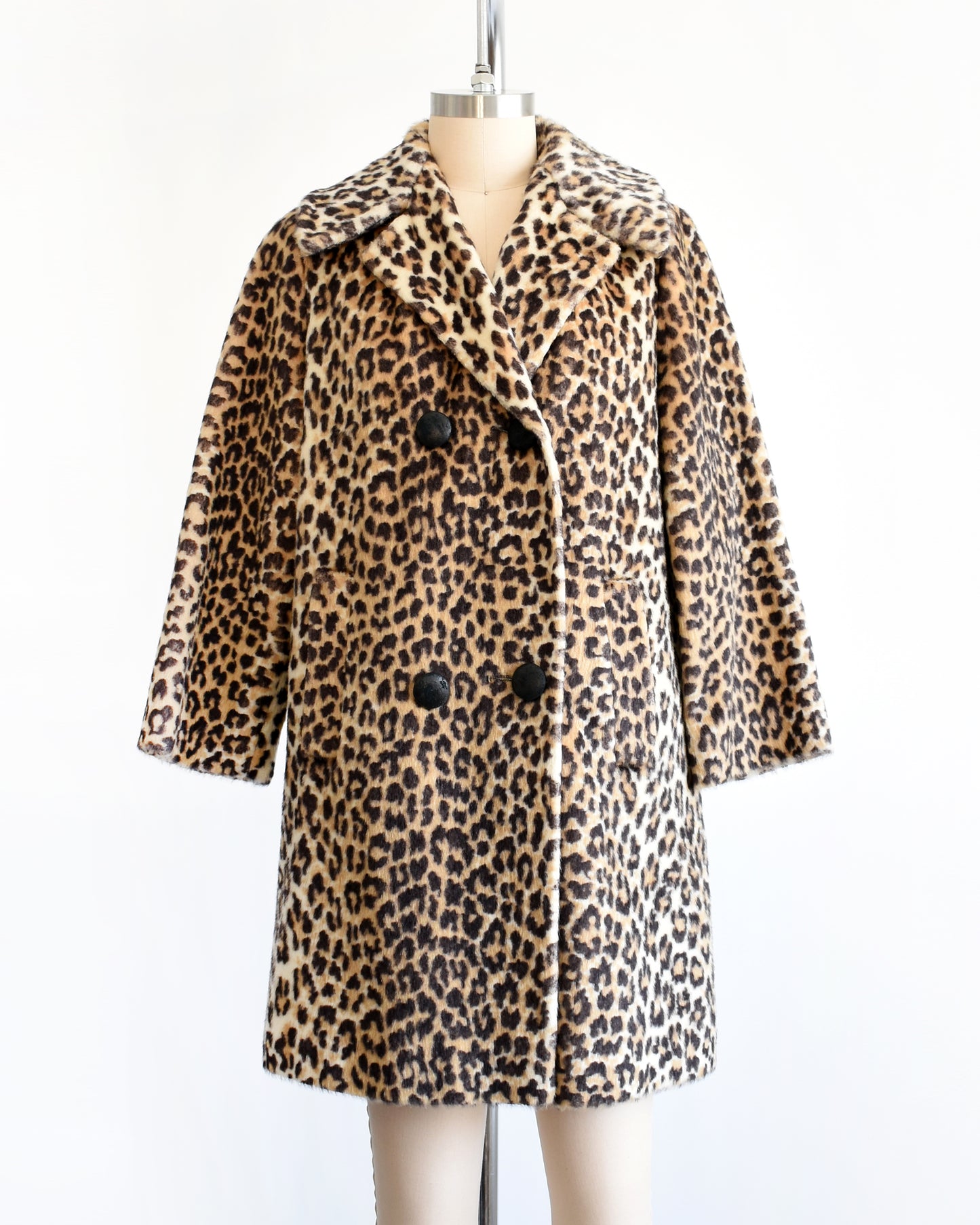 a vintage late 1960s early 1970s faux fur leopard print coat with four black buttons