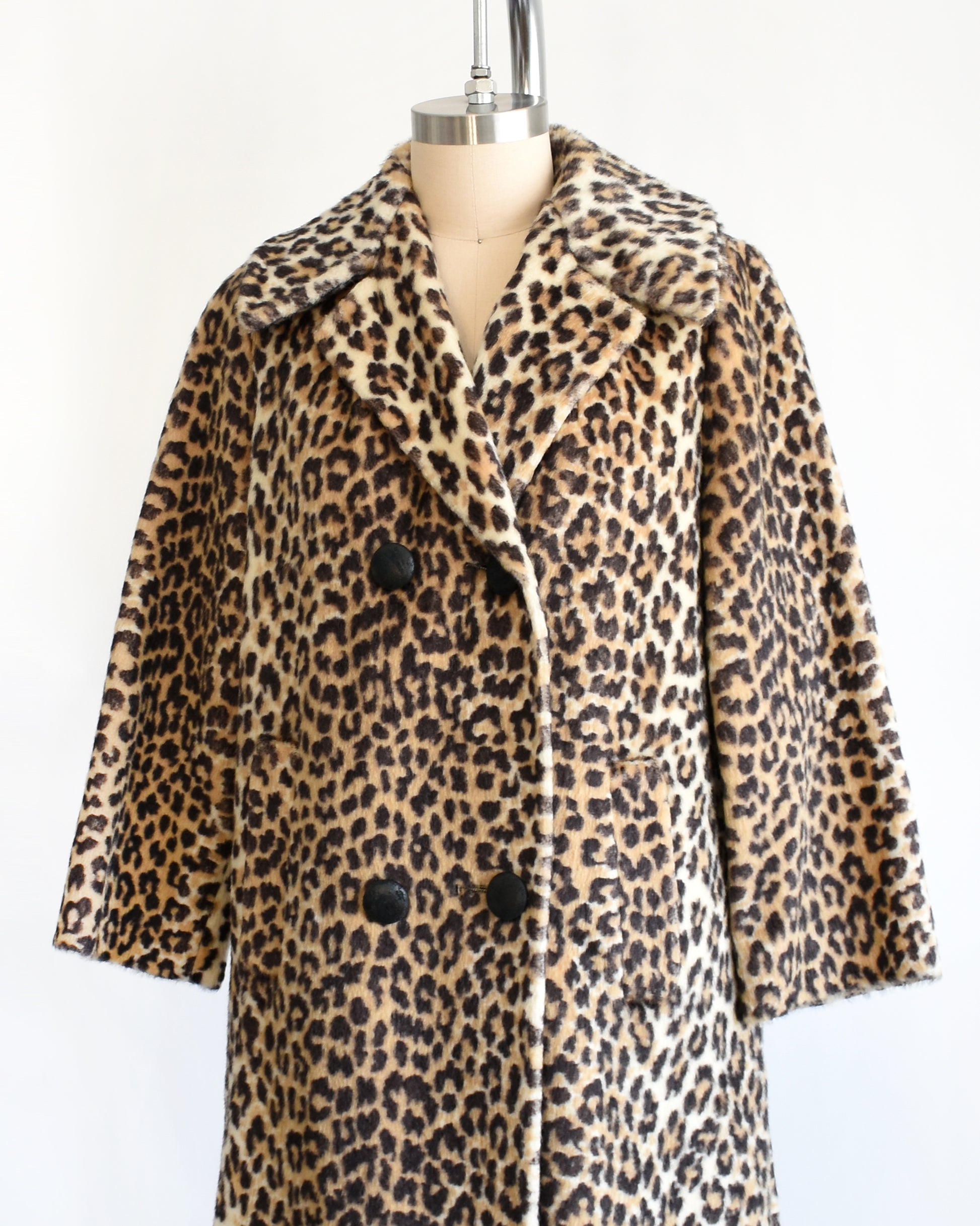 side front view of a vintage late 1960s early 1970s faux fur leopard print coat with four black buttons