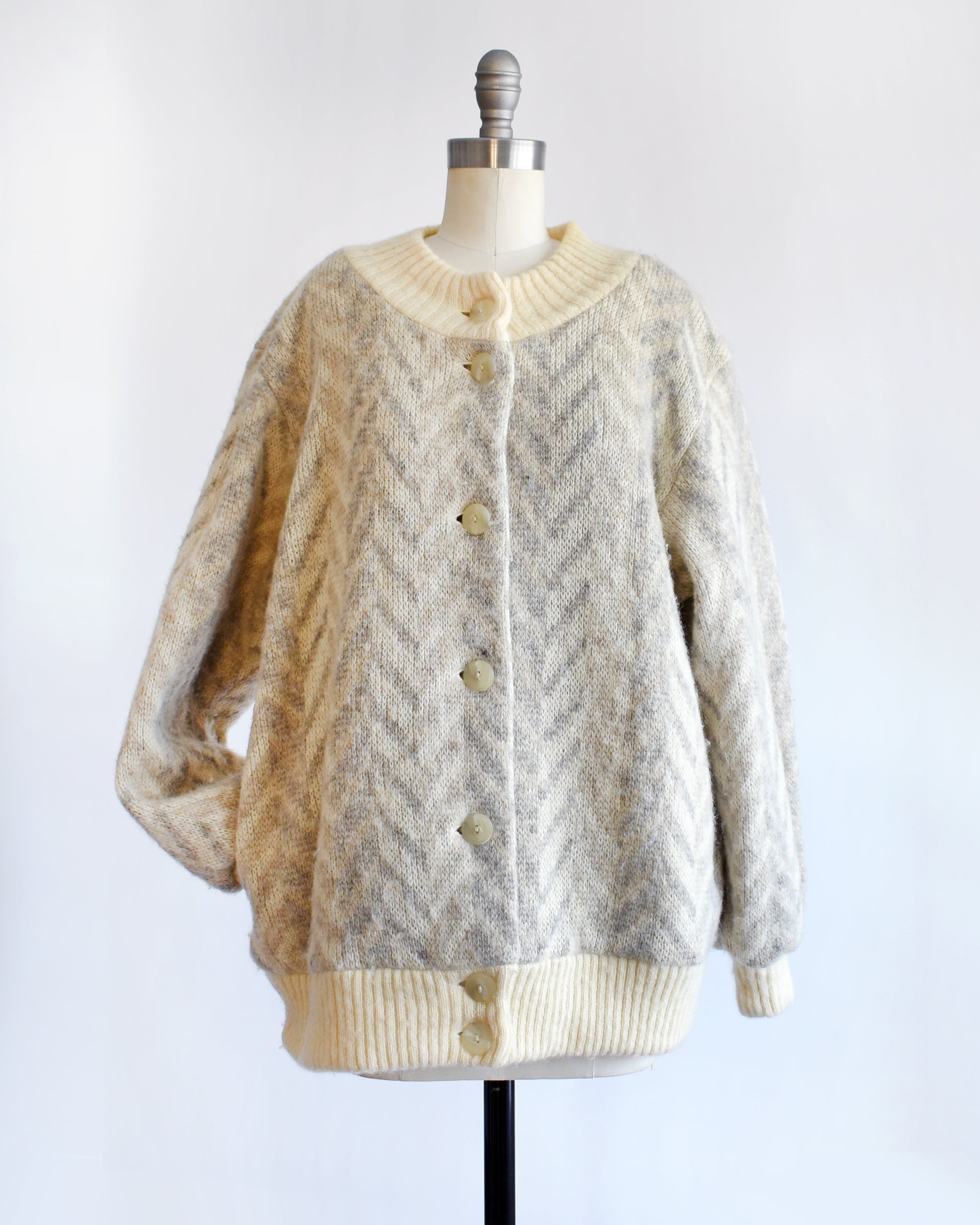 a vintage 1970s Icelandic knitted cardigan on a mannequin against a white background. The arm is in one of the pockets.