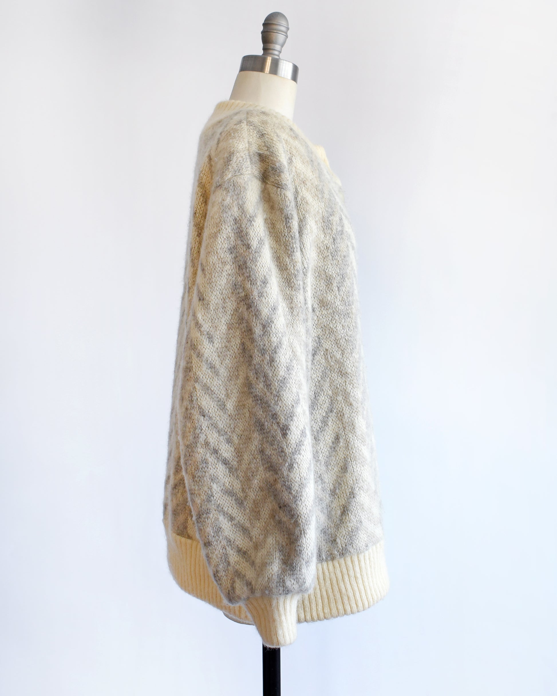 side view of a vintage 1970s Icelandic knitted cardigan on a mannequin against a white background