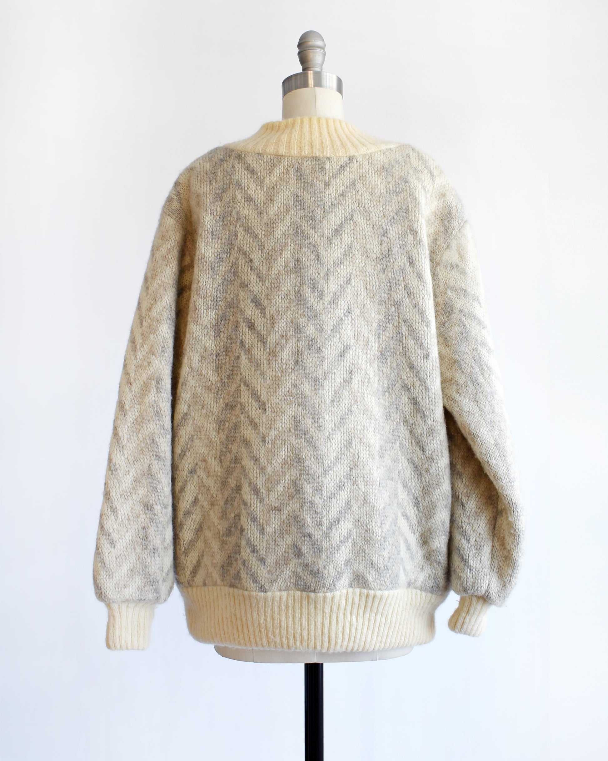 back view of a vintage 1970s Icelandic knitted cardigan on a mannequin against a white background