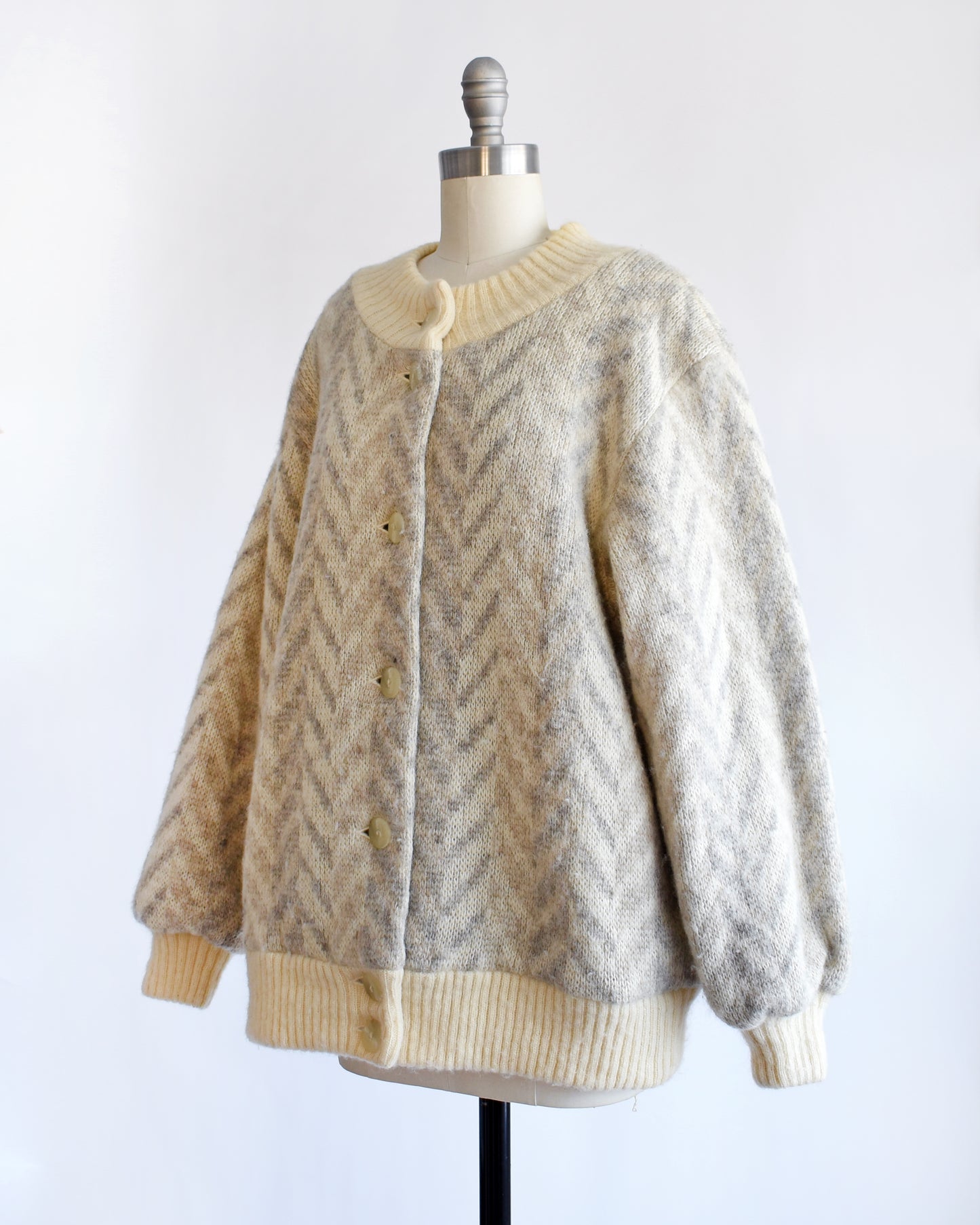 side front view of a vintage 1970s Icelandic knitted cardigan on a mannequin against a white background
