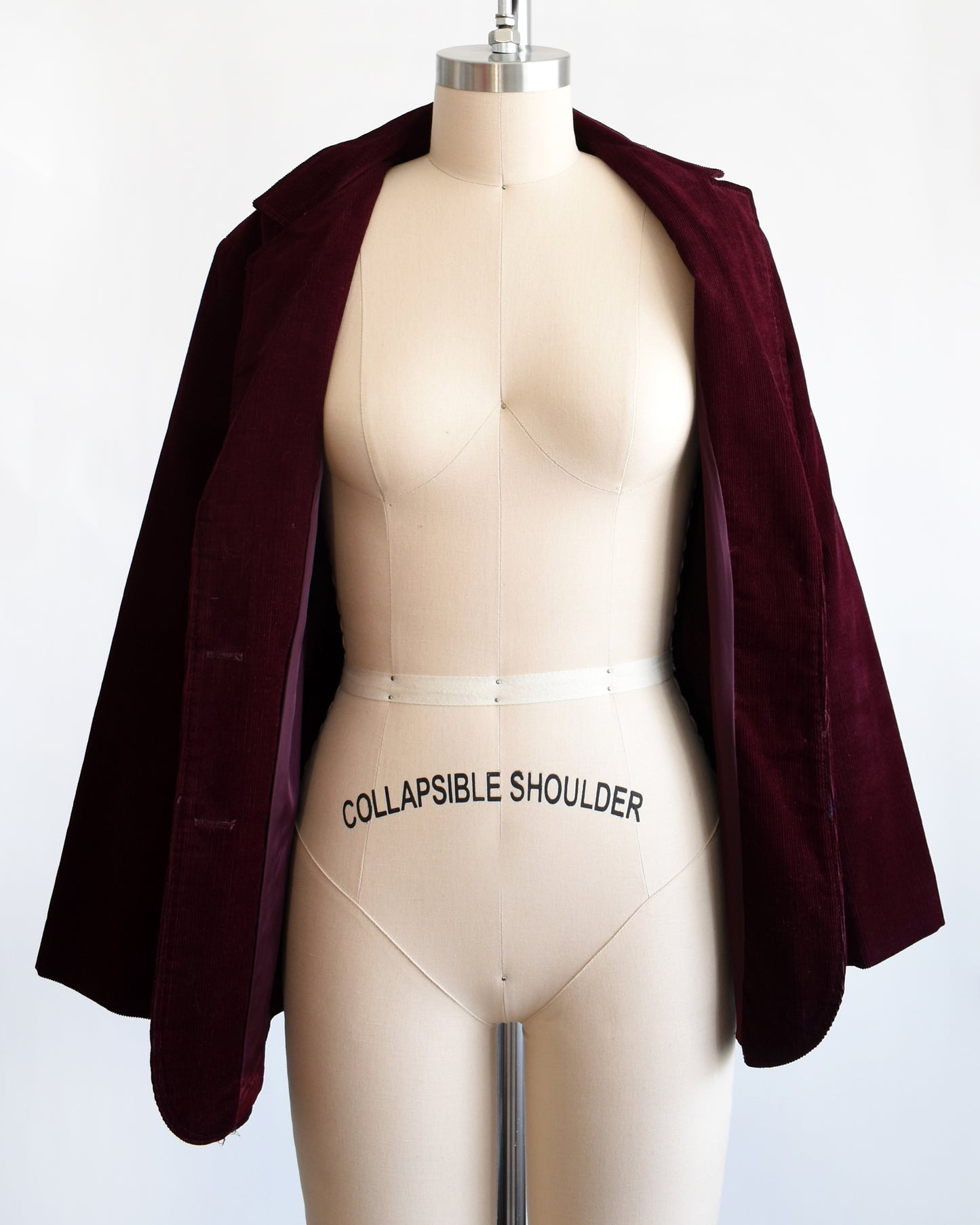 A vintage 1980s burgundy blazer which is open showing the matching lining
