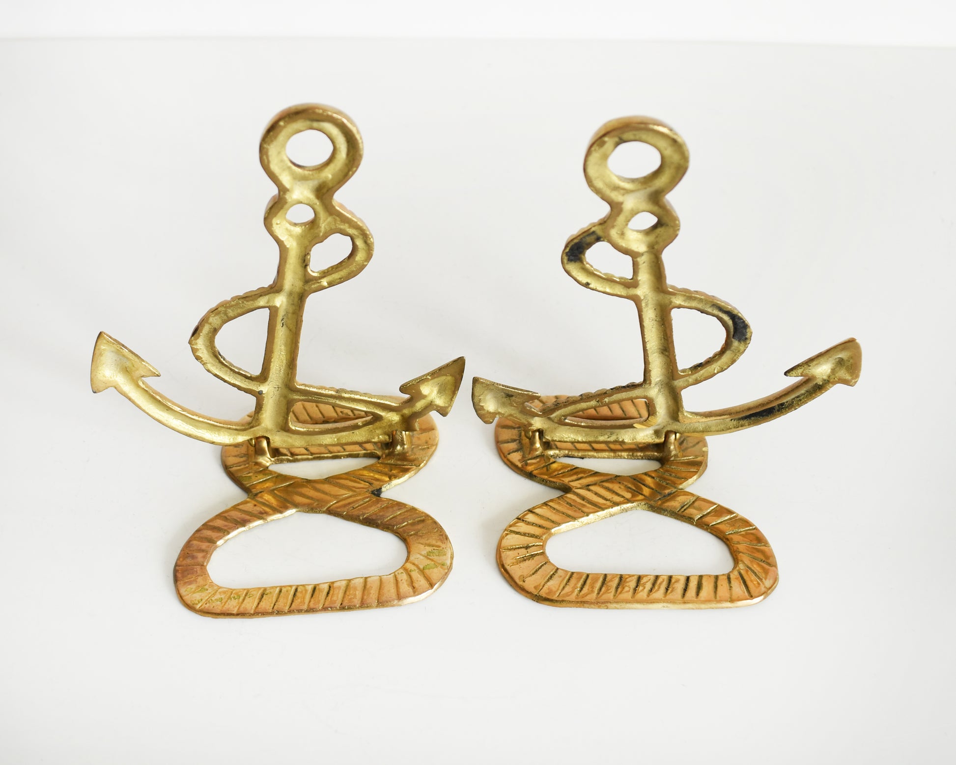 Back view of two vintage brass anchor and rope bookends.