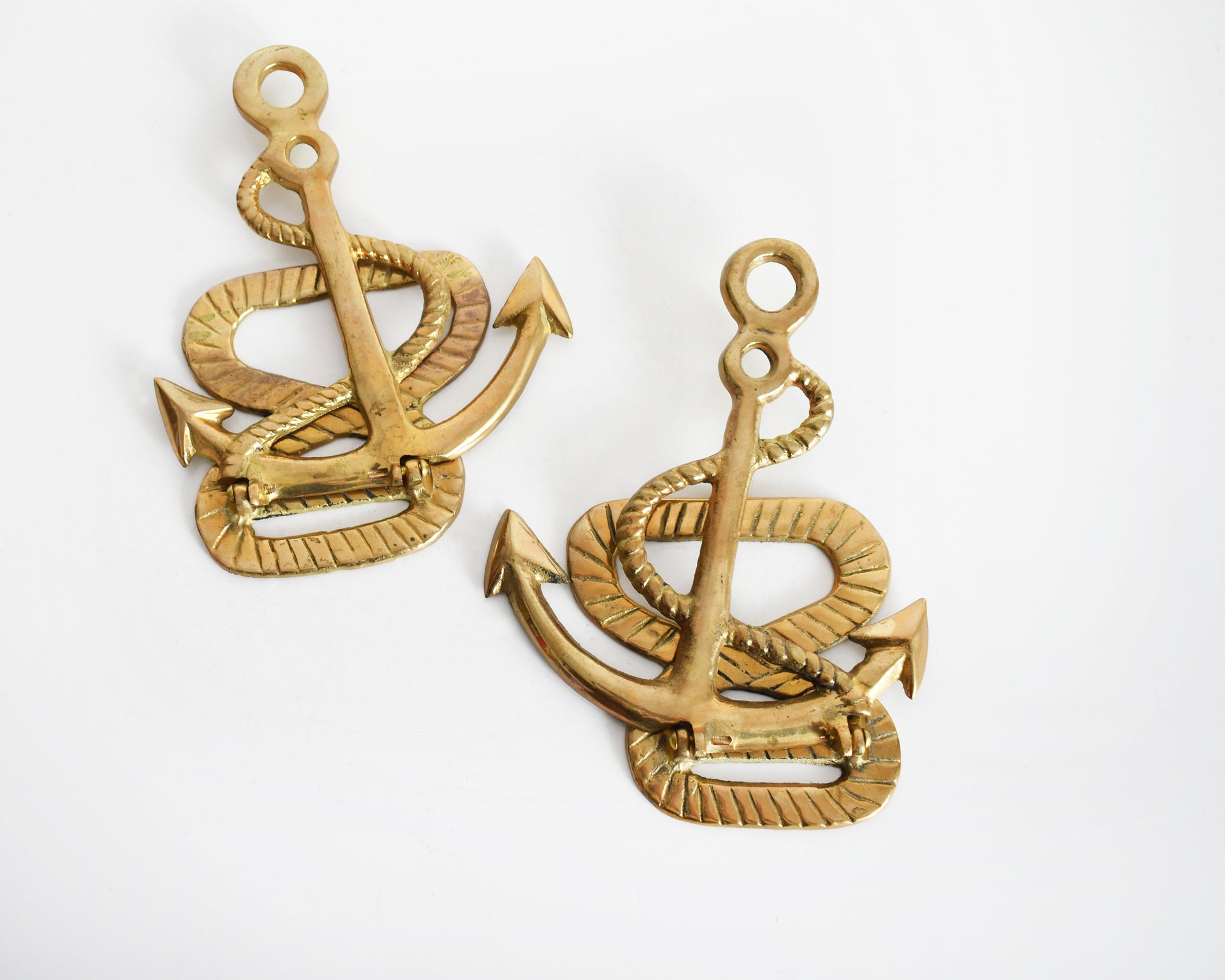 Two vintage brass anchor and rope bookends. The anchors are folded down in this photo