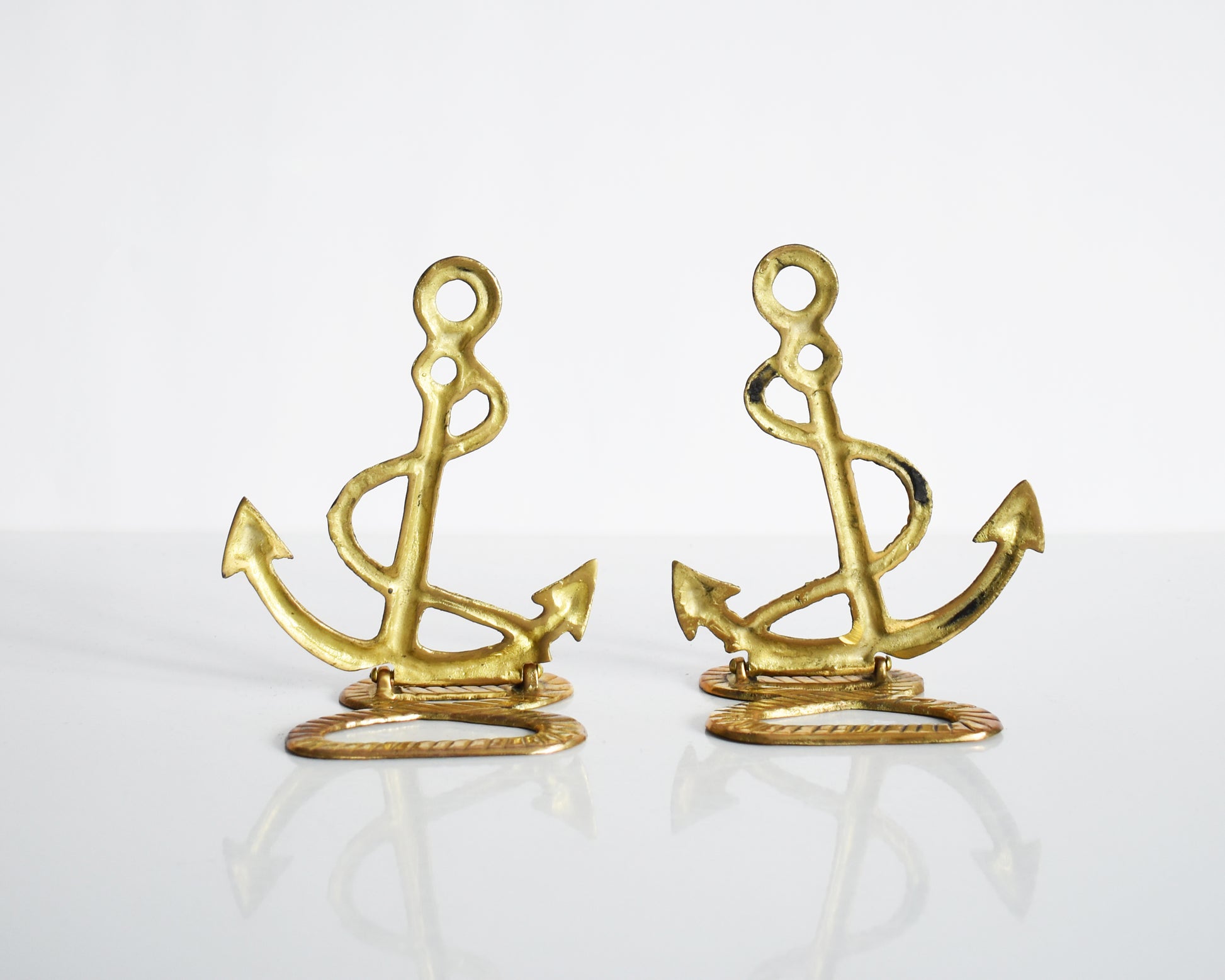 back views of two vintage brass anchor and rope bookends.