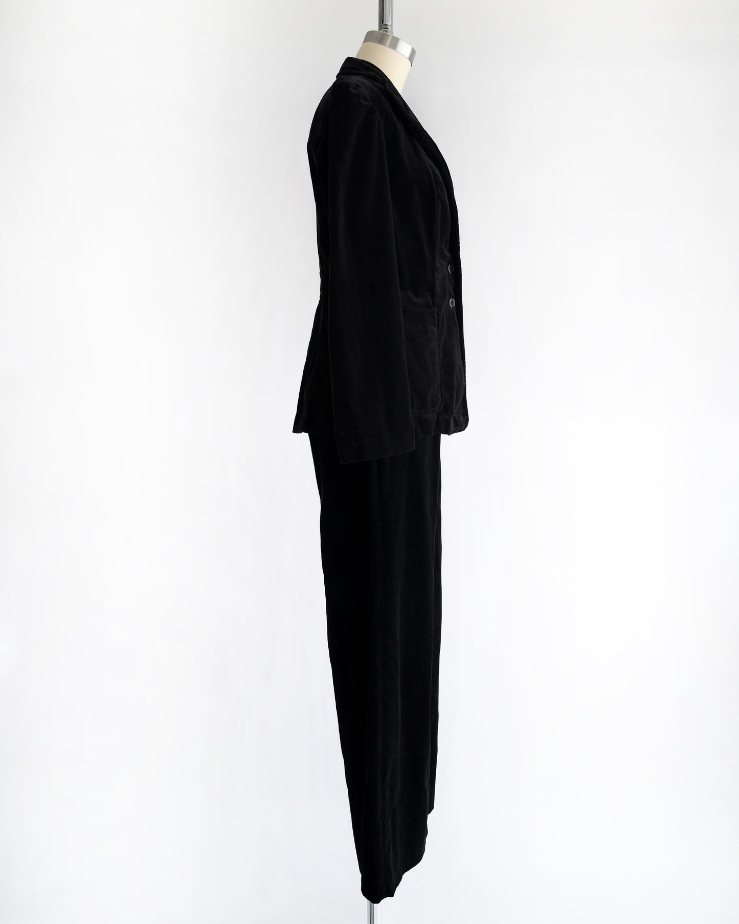 side view of a vintage 1970s black velvet pant set on a mannequin against a white background