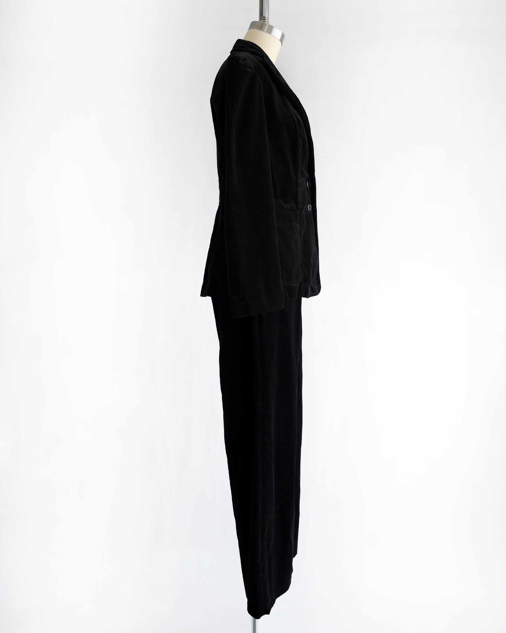 side view of a vintage 1970s black velvet pant set on a mannequin against a white background