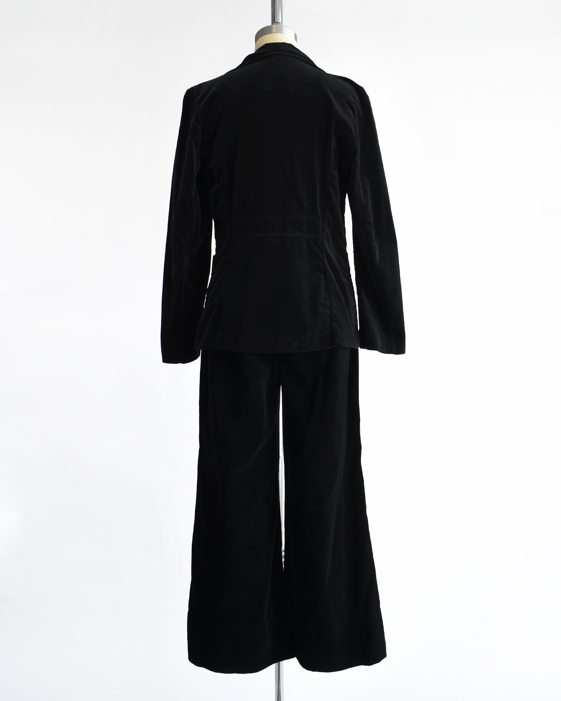 back view of a vintage 1970s black velvet pant set on a mannequin against a white background
