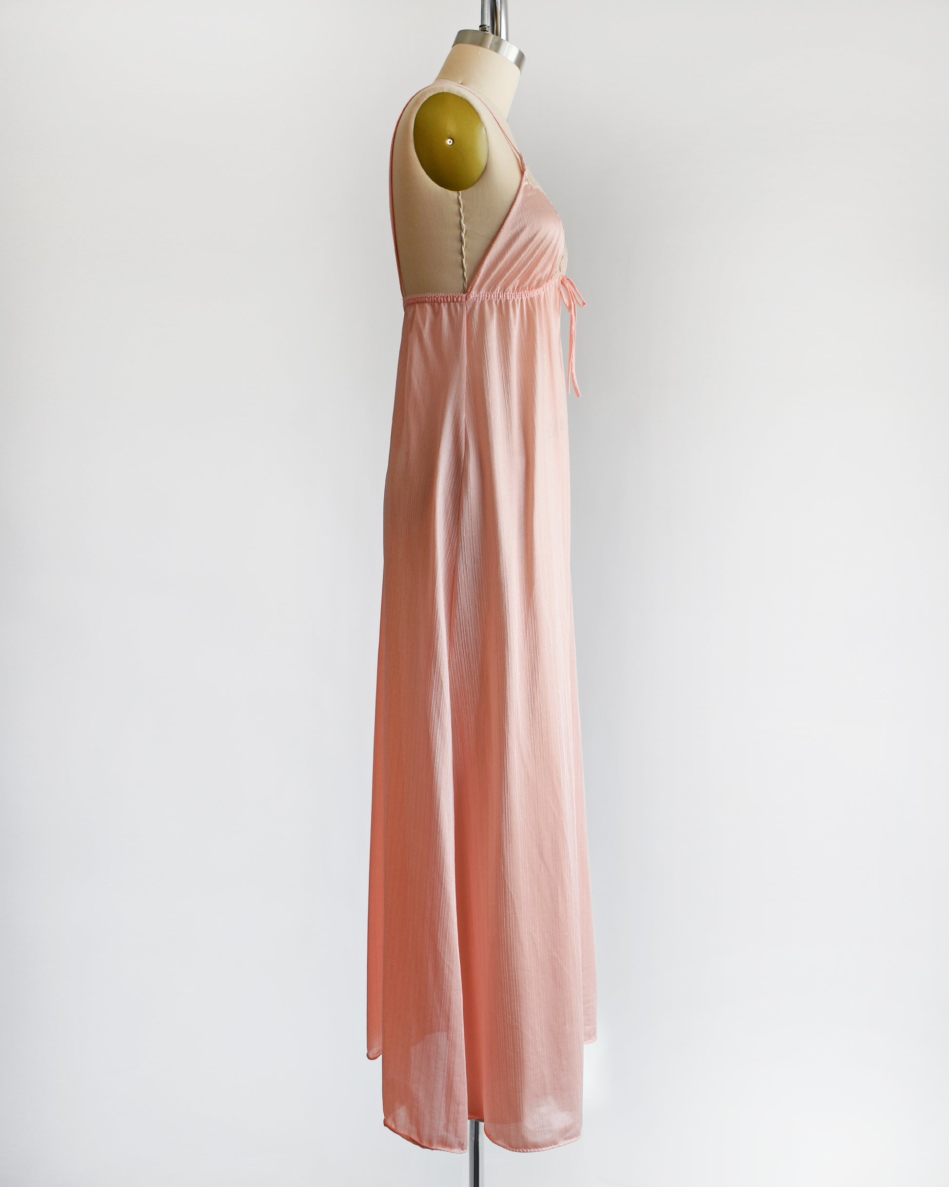 Side view of a A vintage 1970s peachy pink nightgown 