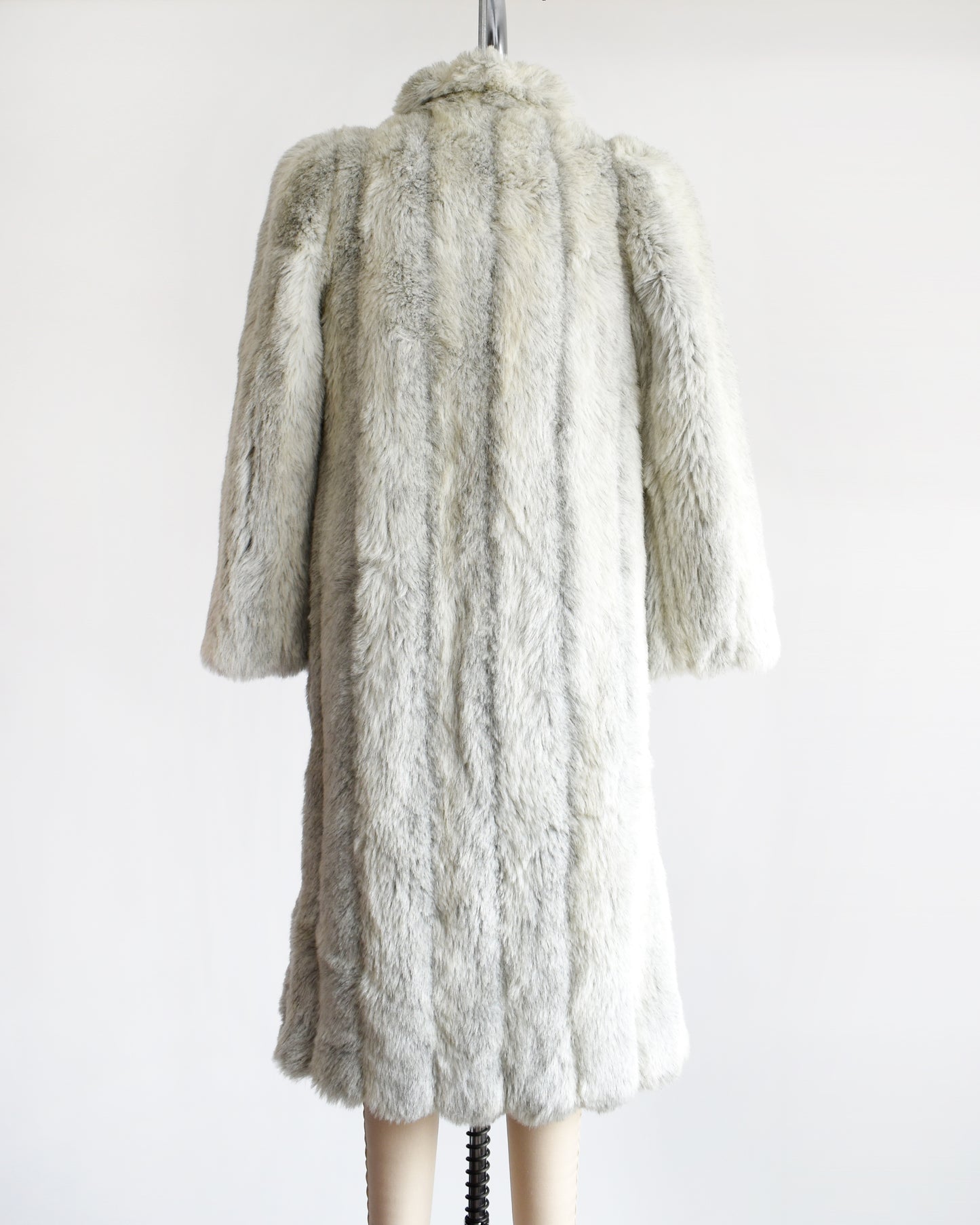 Back view of a vintage 1980s  cream colored faux fur coat with light and dark gray stripes. 