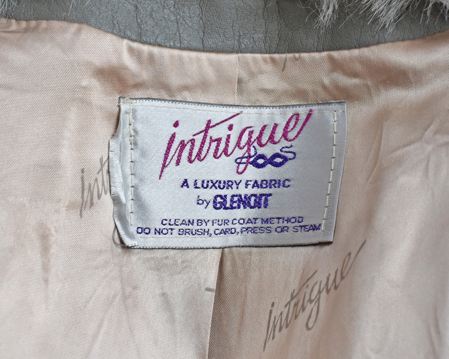 Close up of the tag which says Intrigue, a luxury fabric by Glenoit