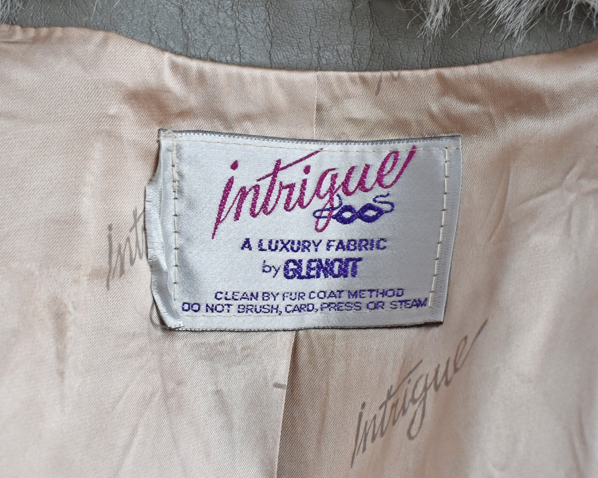 Close up of the tag which says Intrigue, a luxury fabric by Glenoit
