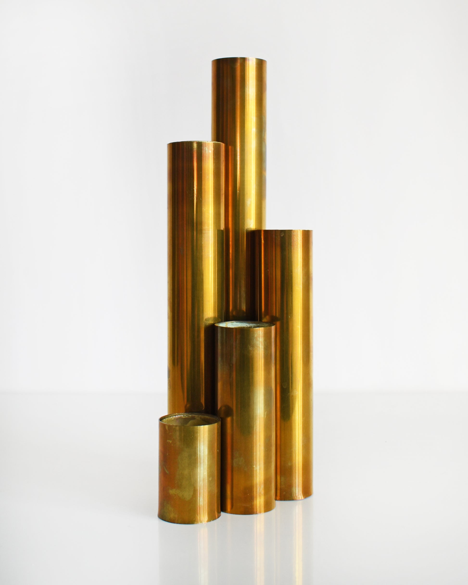 Five mid century brass cylindrical candle holders in different sizes