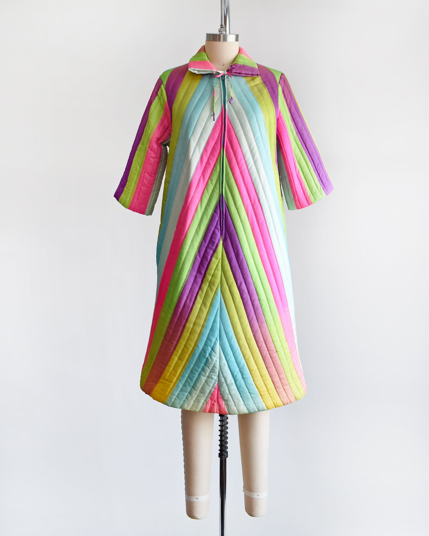 A vintage 1960s rainbow striped quilted robe with  purple, pink, blue, and green stripes