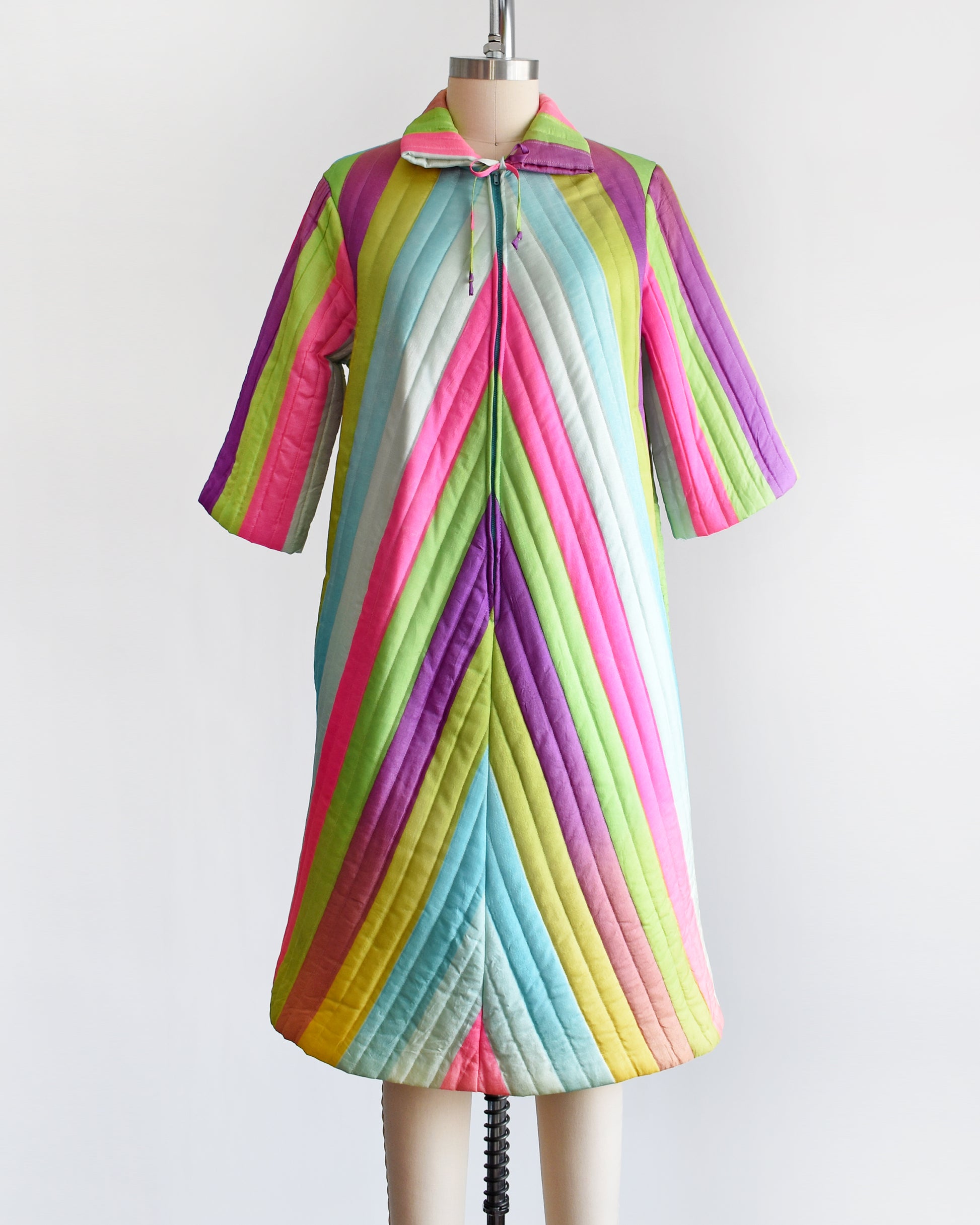 A vintage 1960s rainbow striped quilted robe with  purple, pink, blue, and green stripes