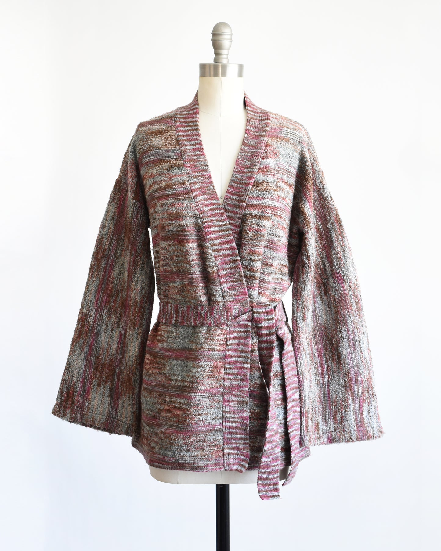 A vintage 1970s space dye wrap cardigan on a dress form against a white background