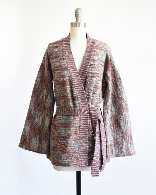 A vintage 1970s space dye wrap cardigan on a dress form against a white background