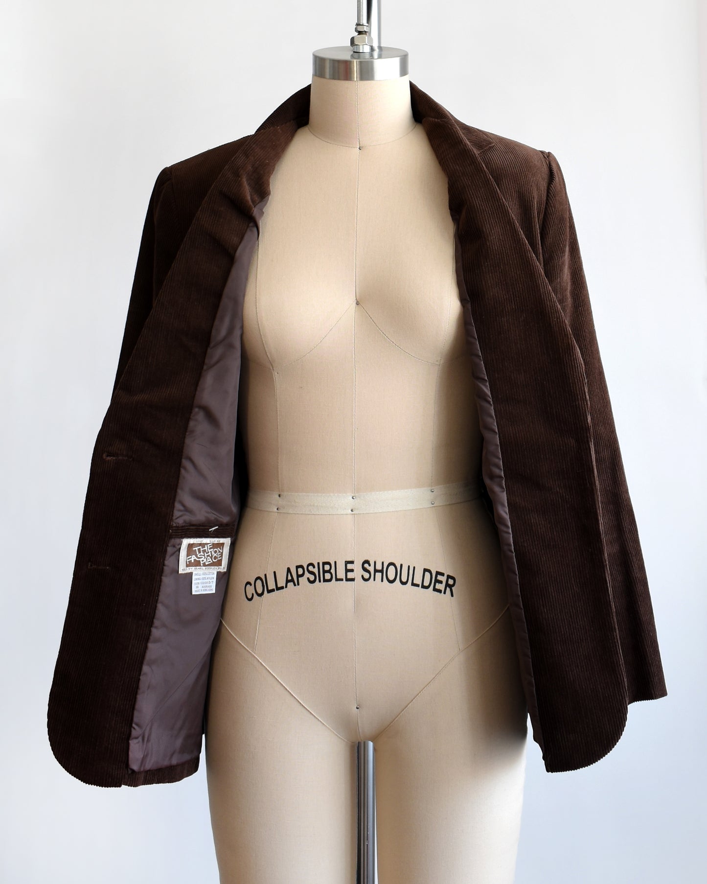 A vintage 1970s brown corduroy blazer that's open showing the brown lining